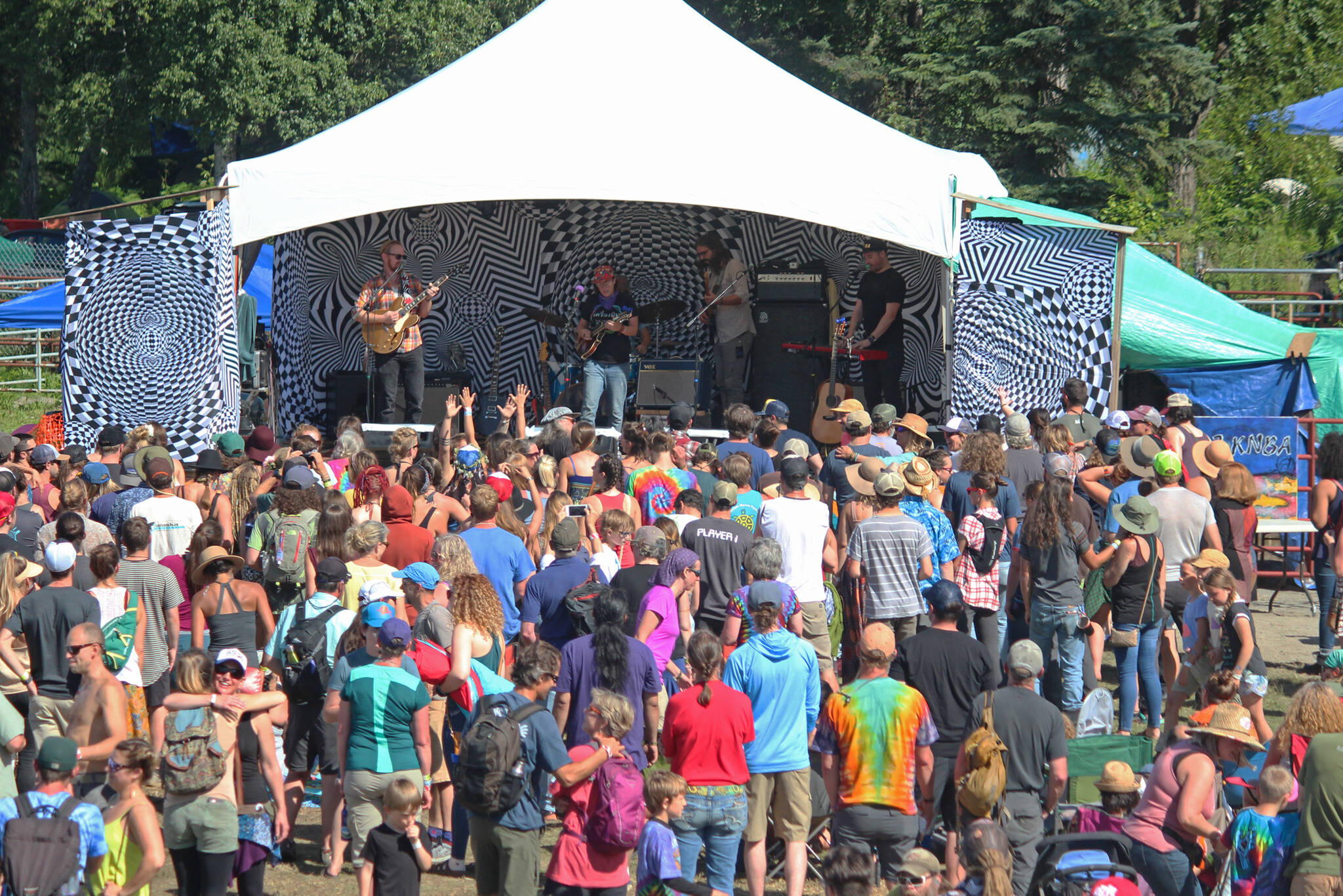 Music lovers listen to a performance on the River Stage at Salmonfest on Saturday, Aug. 4, 2018, in Ninilchik, Alaska. (Photo by Megan Pacer/Homer News)