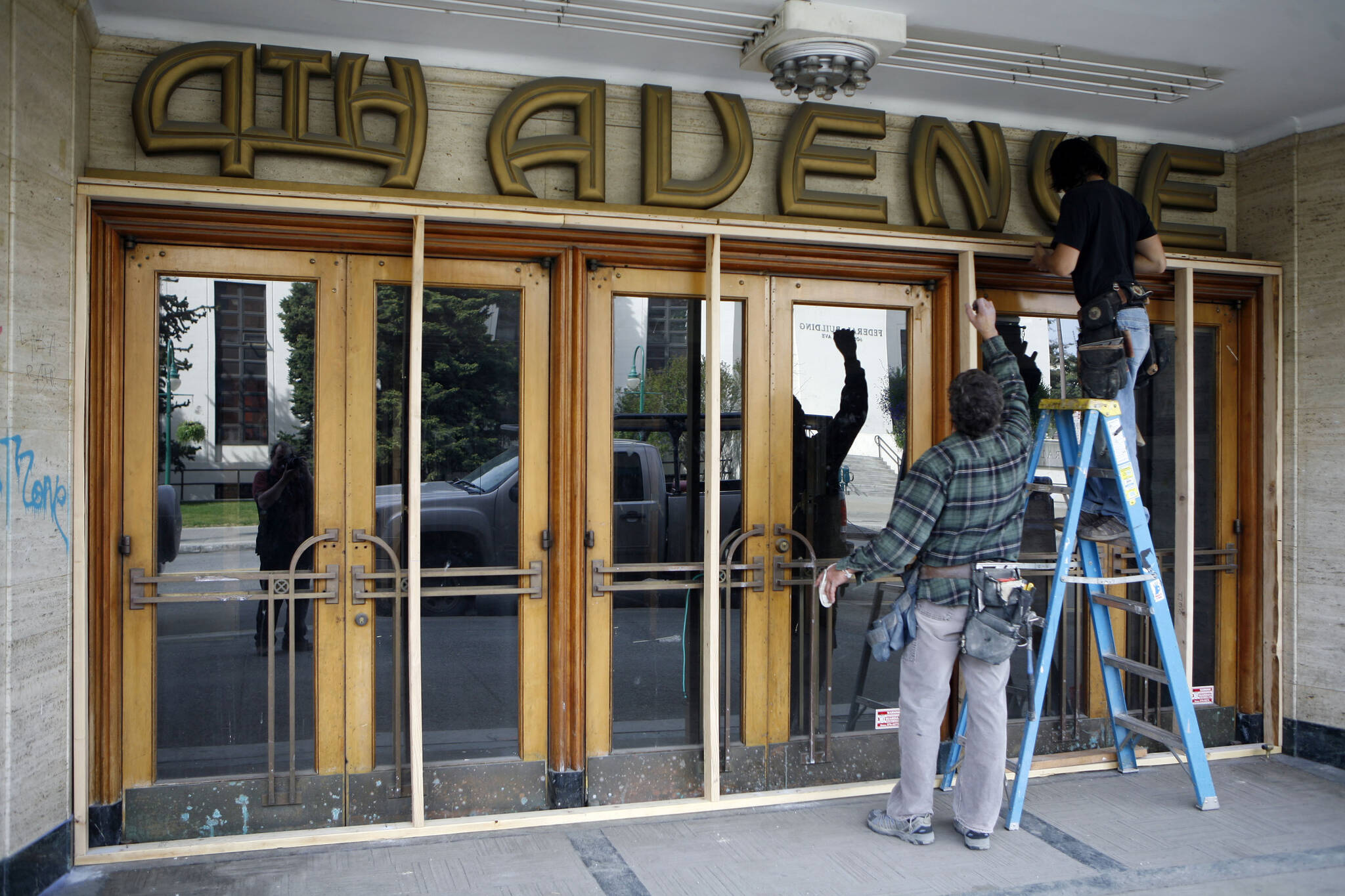 Jeff Griffin, left, and RC Edwardsen board up the 4th Avenue Theatre in downtown Anchorage, Alaska, on May 22, 2009. Demolition will begin in August 2022 on a once-opulent downtown Anchorage movie theater designed by the architect of Hollywood’s famed Pantages Theater. The 4th Avenue Theatre with nearly 1,000 seats opened in 1947, and it withstood the second most powerful earthquake ever recorded. (AP Photo/Al Grillo, File)
