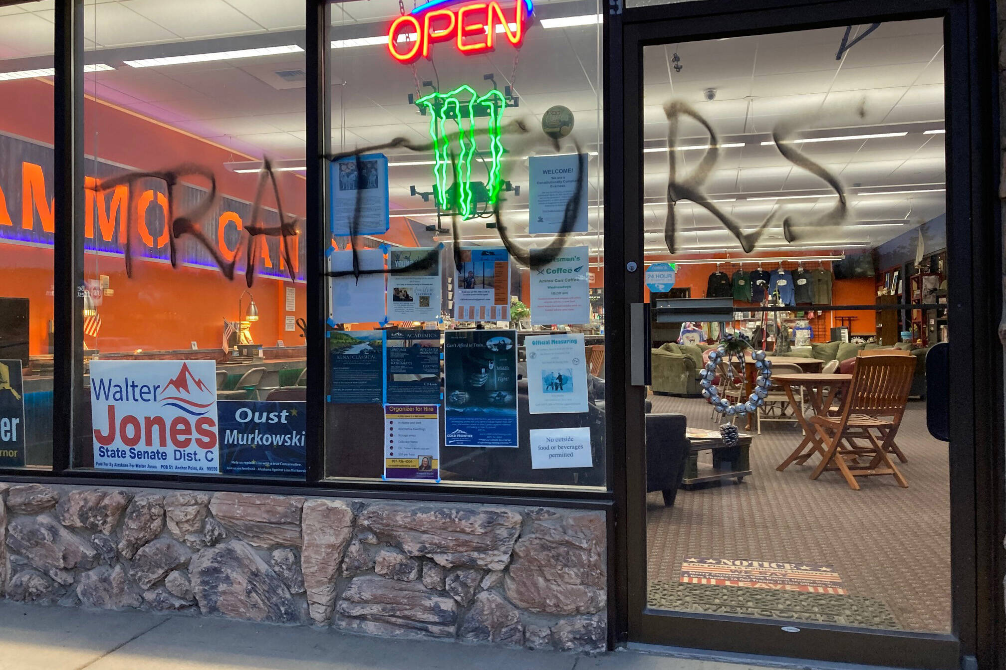 Graffiti can be seen on the front of Ammo-Can Coffee in Soldotna, on Monday, Aug. 8, 2022, in Soldotna, Alaska. The conservative social club and coffee shop reported Monday that someone had vandalized the storefront and glued the locks. (Photo courtesy Ammo-Can Coffee)