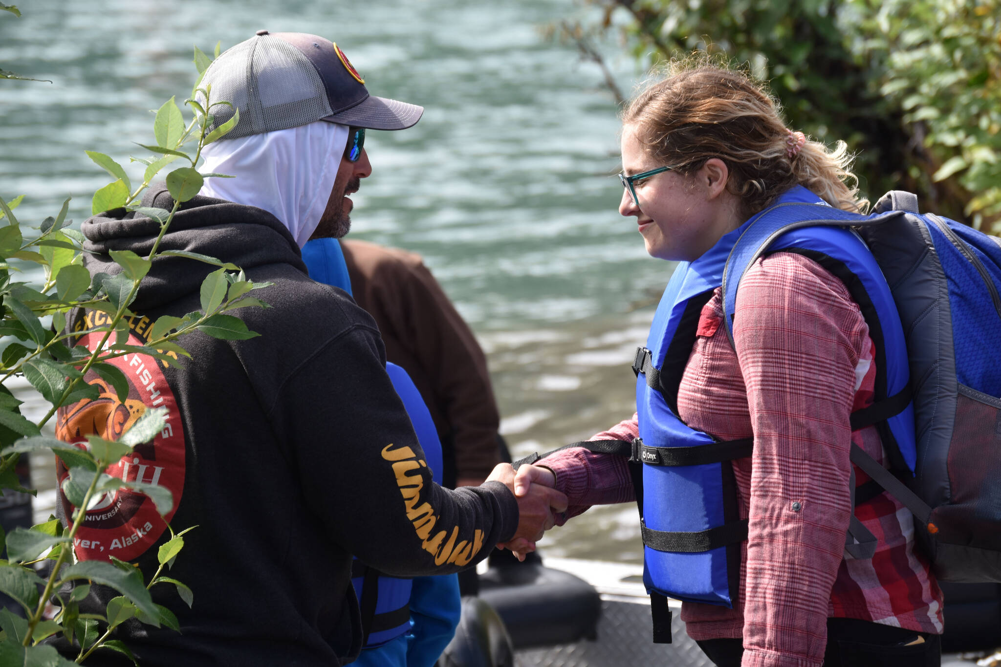 A fishing guide greets one of his passengers at the Kenai River Junior Classic in Soldotna, Alaska, on Aug. 10, 2022. (Jake Dye/Peninsula Clarion)