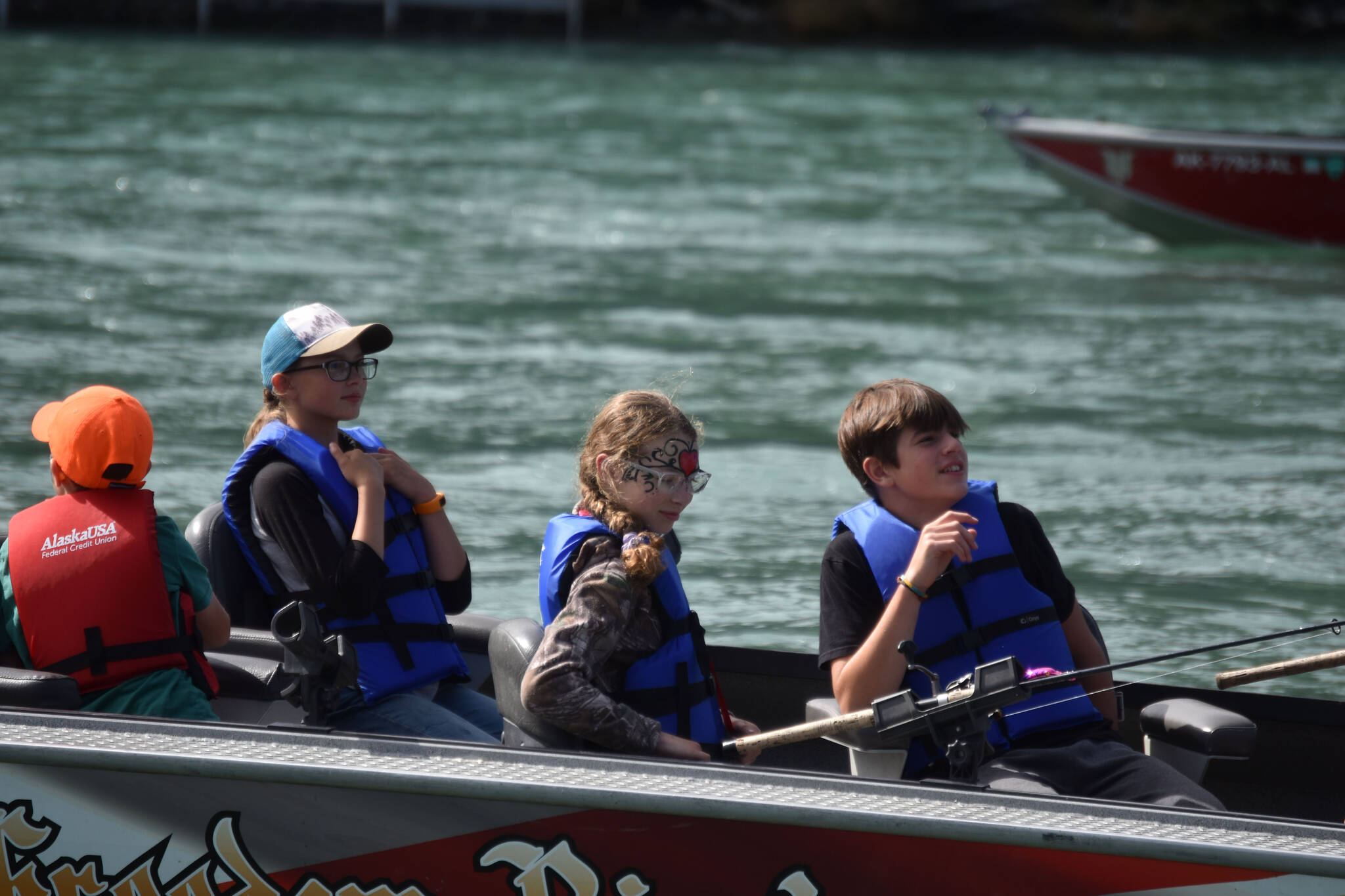 Children ride a fishing boat onto the Kenai River during the Kenai River Junior Classic in Soldotna, Alaska, on Aug. 10, 2022. (Jake Dye/Peninsula Clarion)