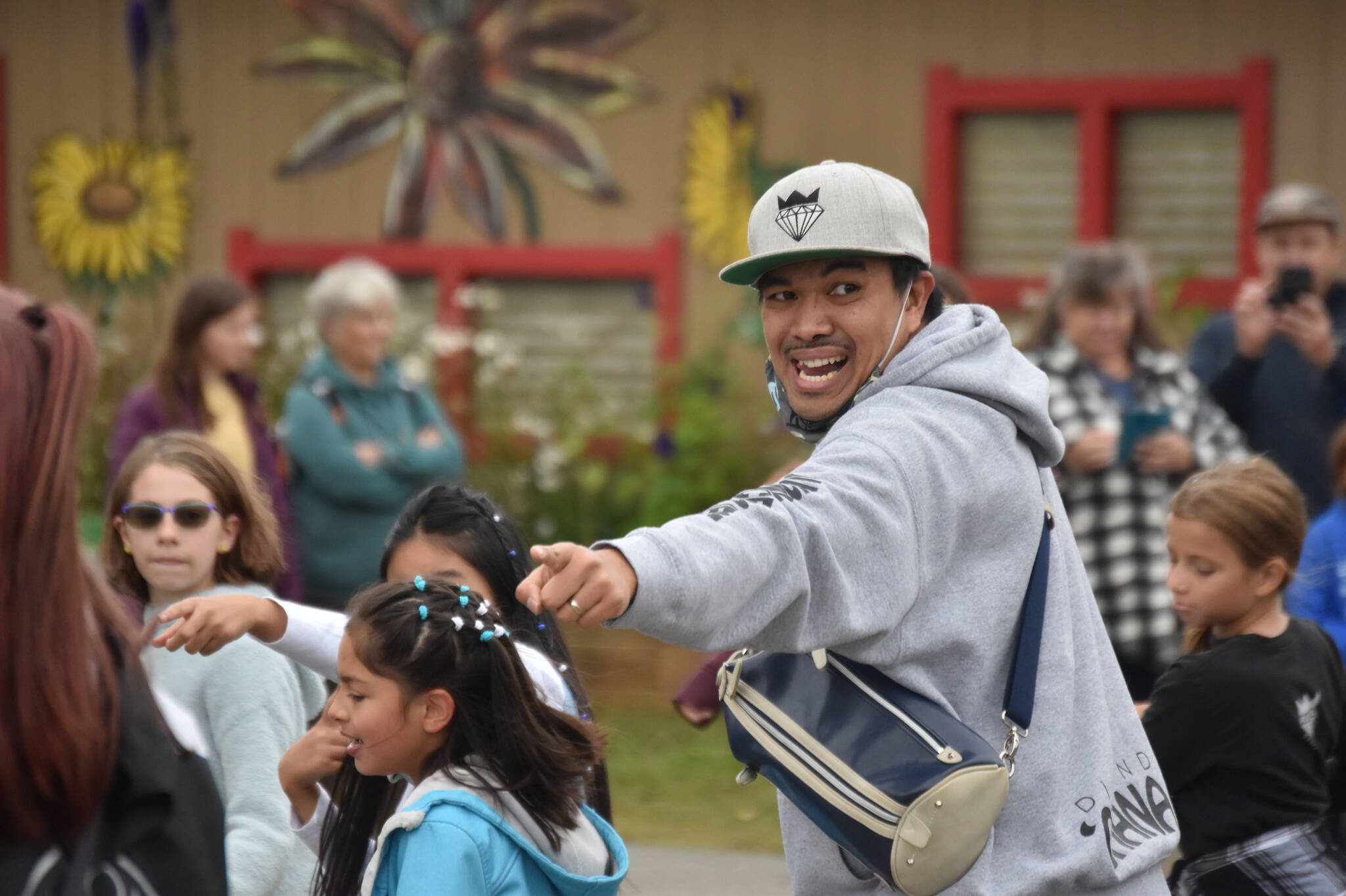 The head of a dance troupe leads both dancers and passerby in a flash mob style performance at the Kenai Peninsula Fair on Aug. 12, 2022, in Ninilchik, Alaska. (Jake Dye/Peninsula Clarion)