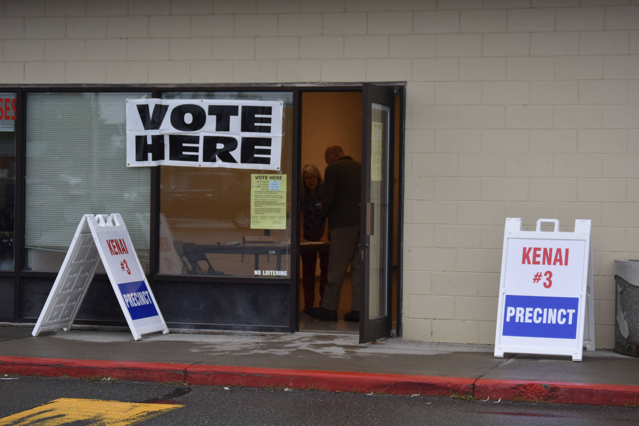 Sheree Van Natta speaks to a voter at the Kenai Mall, polling place for Precinct 3 voters, on Tuesday, Aug. 16, 2022 in Kenai, Alaska. (Jake Dye/Peninsula Clarion)