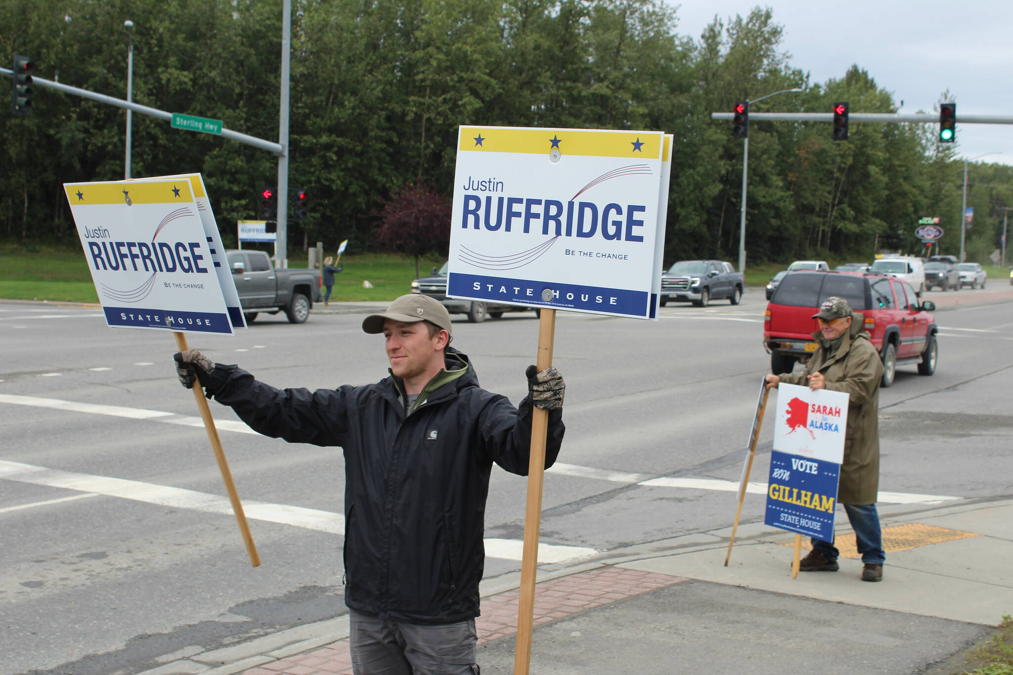 Braeden Garrett holds signs supporting Alaska House of Representatives candidate Justin Ruffridge at the intersection of the Kenai Spur and Sterling highways on Tuesday, Aug. 16, 2022, in Soldotna, Alaska. (Ashlyn O’Hara/Peninsula Clarion)