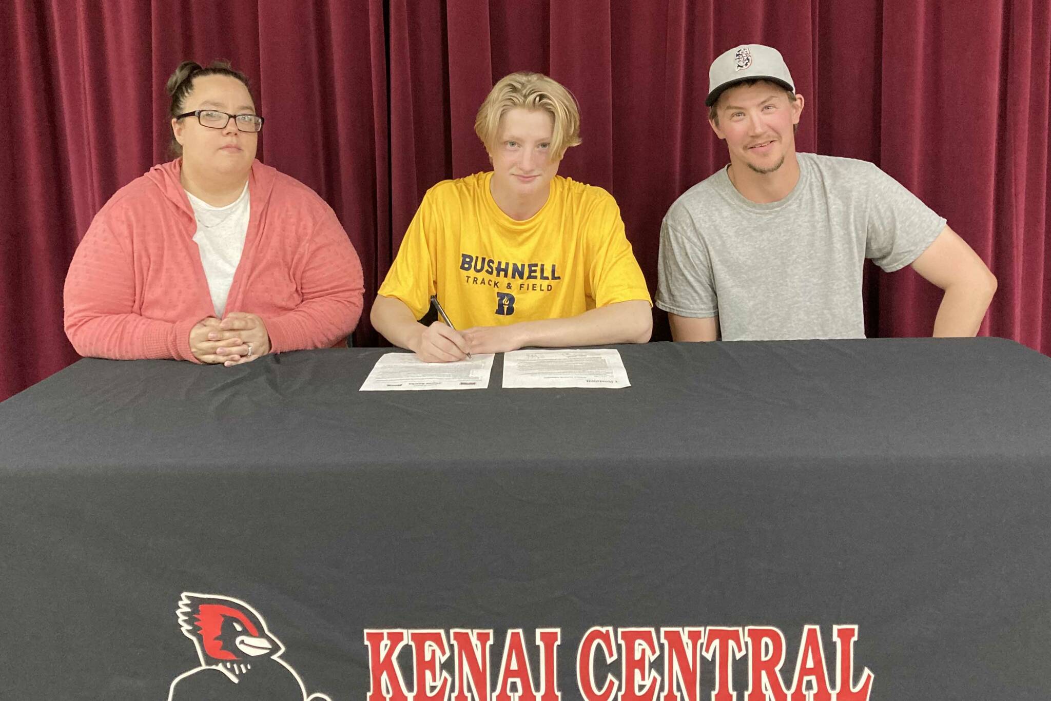 James Sparks, center, signs a National Letter of Intent with his parents, Angela and Jacob Sparks, on Tuesday, Aug. 16, 2022. (Photo provided)