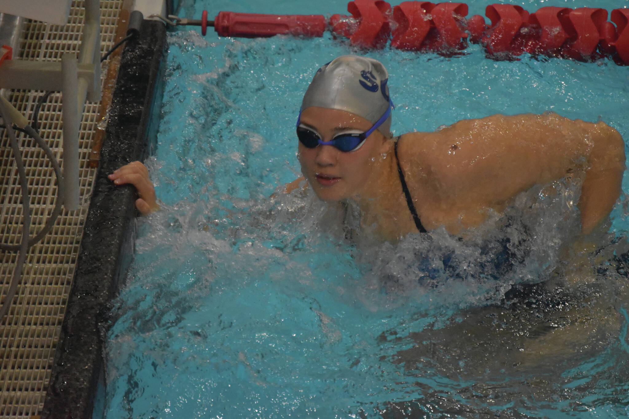 Charisma Watkins, of Soldotna, performs an open turn while swimming in the 100-yard butterfly at Kenai Central High School in Kenai, Alaska, on Aug. 27, 2022. (Jake Dye/Peninsula Clarion)