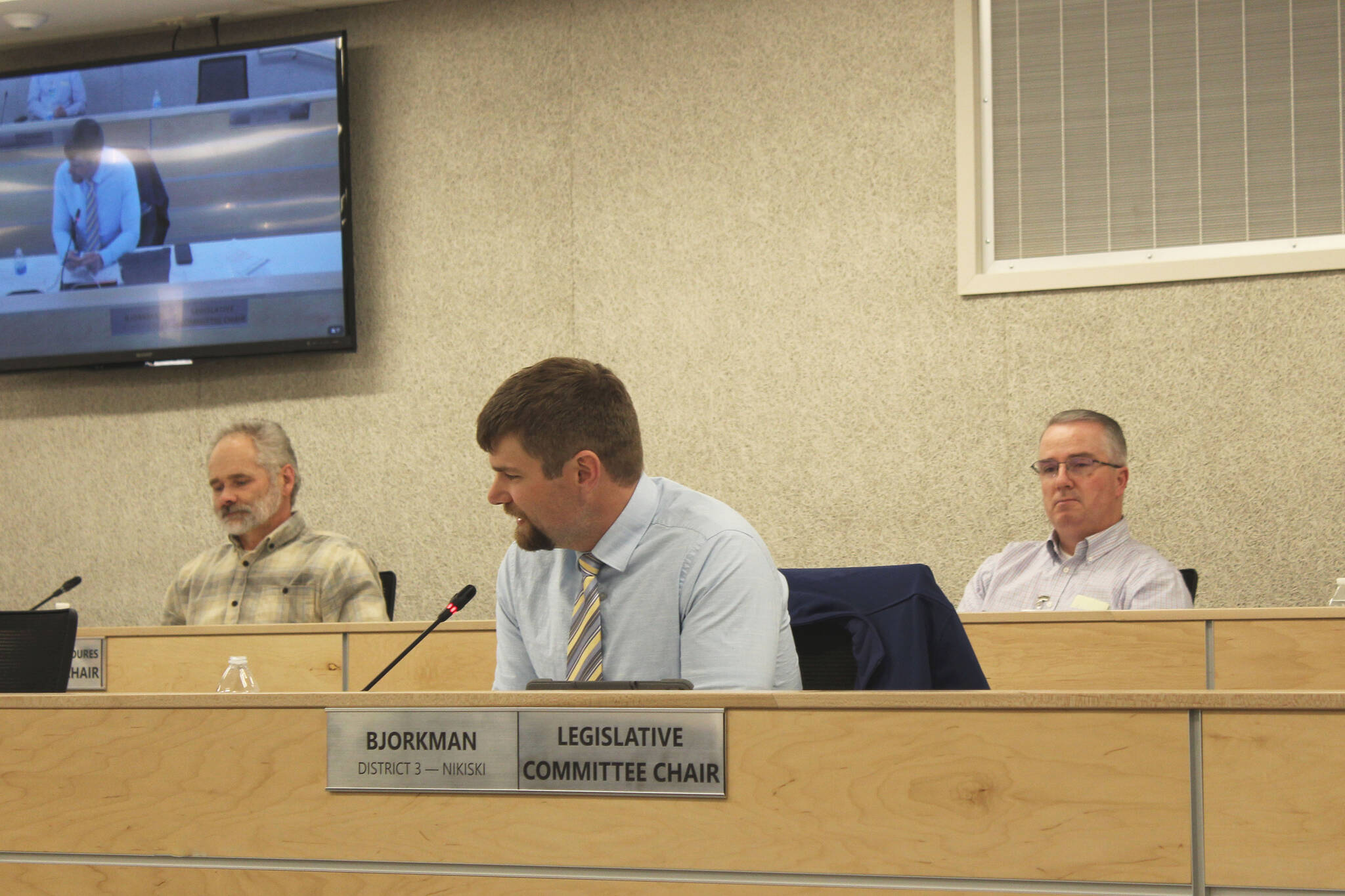 Kenai Peninsula Borough Assembly member Jesse Bjorkman (center) speaks while Aaron Rhoades (right) looks on during an assembly meeting on Tuesday, April 19, 2022 in Soldotna, Alaska. (Ashlyn O’Hara/Peninsula Clarion)