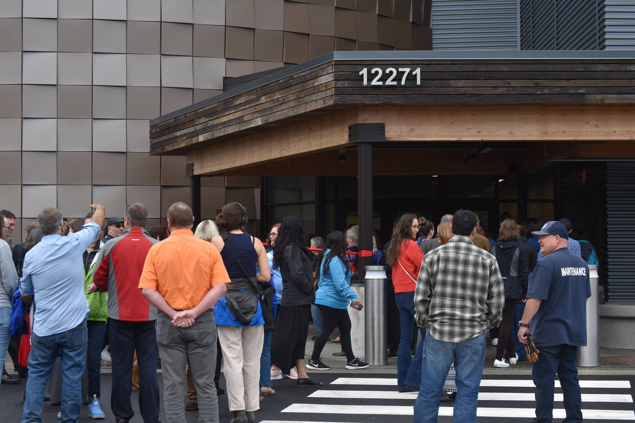 Members of the public and staff wait to enter the Kahtnuht’ana Duhdeldiht Campus during an opening ceremony in Kenai, Alaska on Thursday, Sept. 1, 2022. (Jake Dye/Peninsula Clarion)