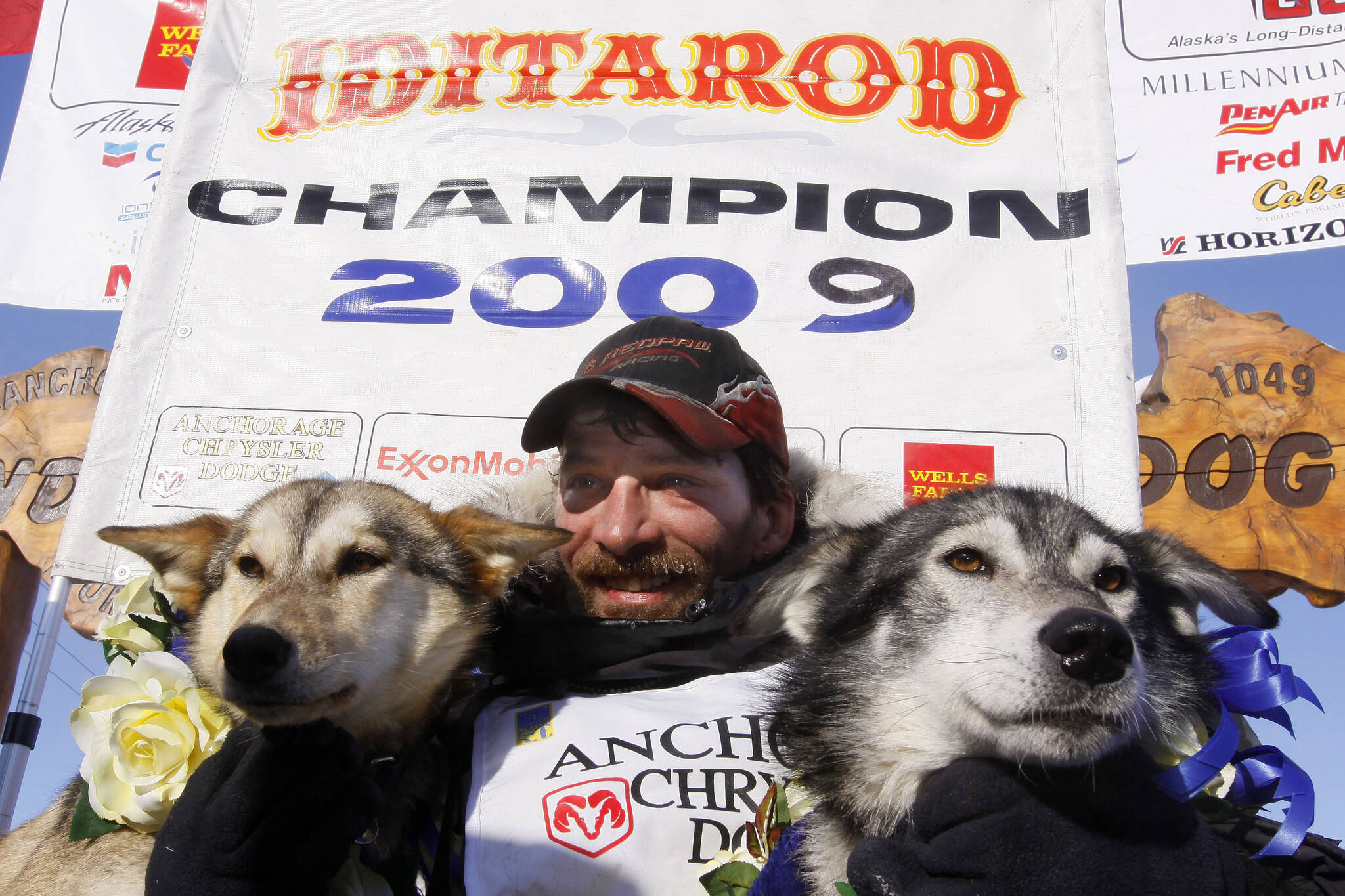 Lance Mackey sits with his lead dogs Larry, right, and Maple after crossing the finish line of the Iditarod Trail Sled Dog Race on March 18, 2009, in Nome, Alaska, to win his third Iditarod in a row. Mackey, a four-time Iditarod Trail Sled Dog Race winner and one of mushing’s most colorful and accomplished champions who also suffered from health and drug issues, died Wednesday, Sept. 7, 2022, his father and kennel announced on Facebook. He was 52. (AP Photo/Al Grillo, File)