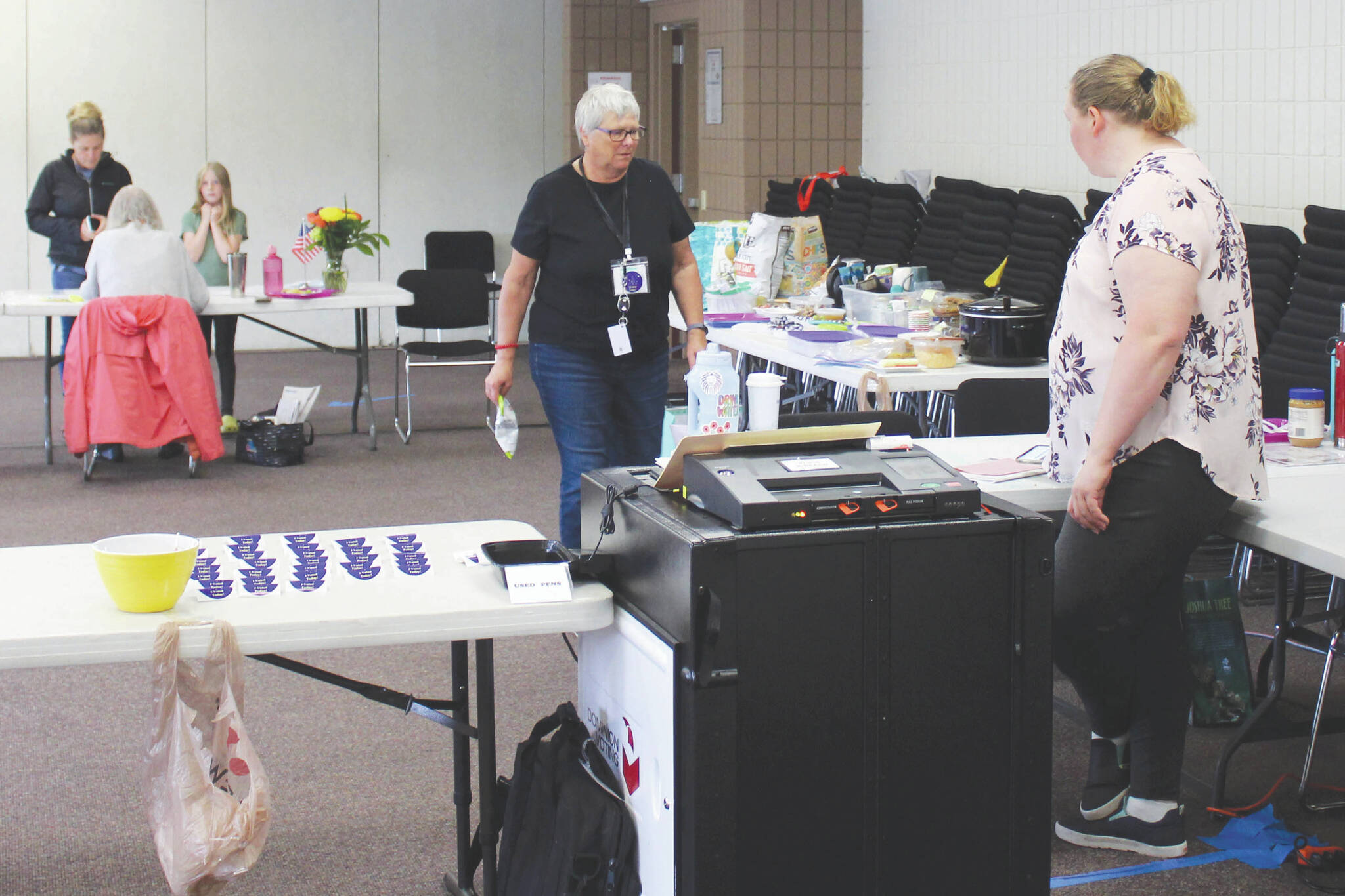 Pollworkers Carol Louthan, center, and Harmony Bolden work at the Soldotna Regional Sports Complex on Tuesday, Aug. 16, 2022, in Soldotna, Alaska. (Ashlyn O’Hara/Peninsula Clarion)