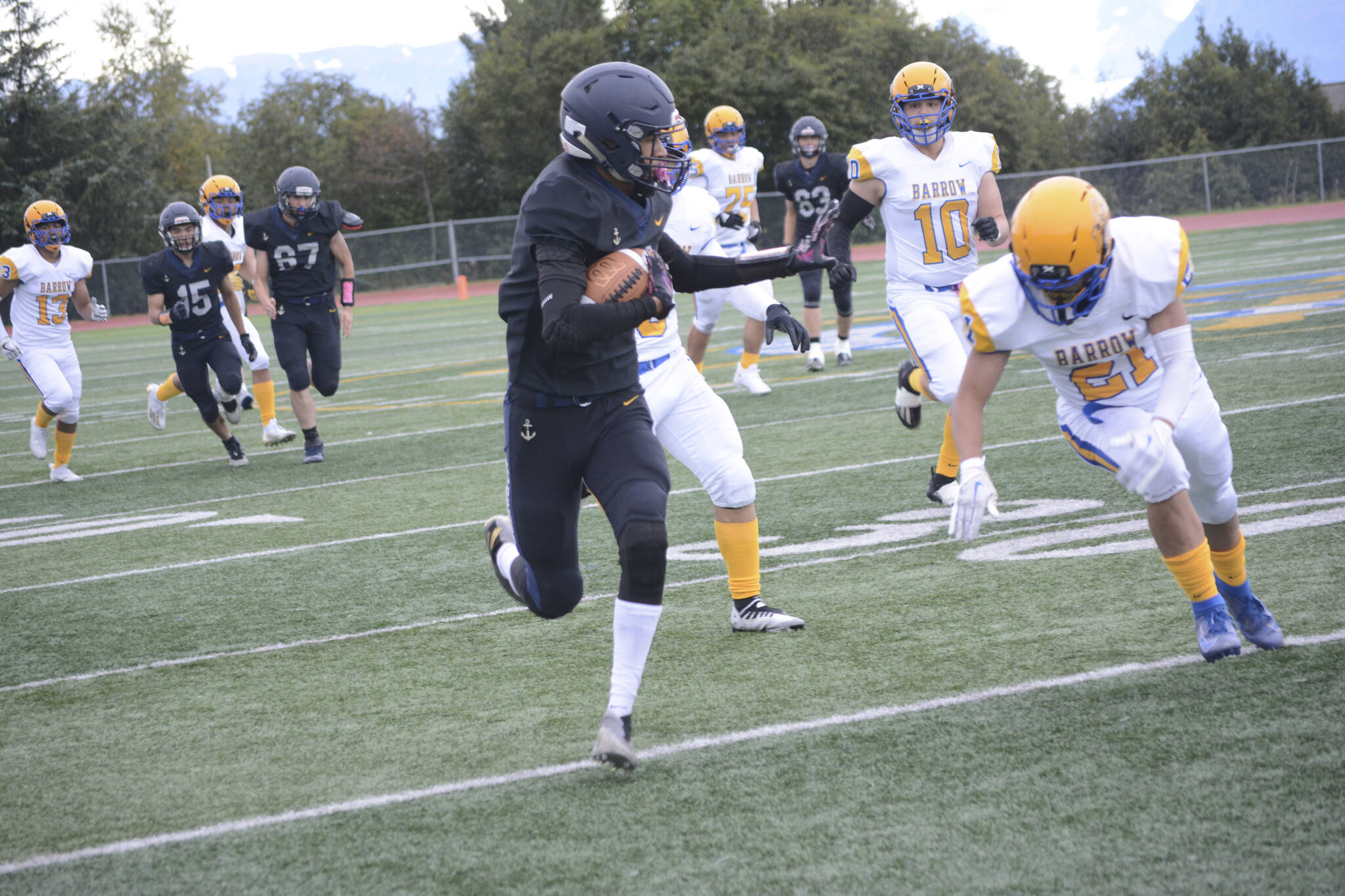 Homer’s Morgan Techie slips by Barrow’s Jason Akpik on a successful run to score Homer’s first touchdown at homecoming on Friday, Sept. 16, 2022, in Homer, Alaska. (Photo by Michael Armstrong/Homer News)