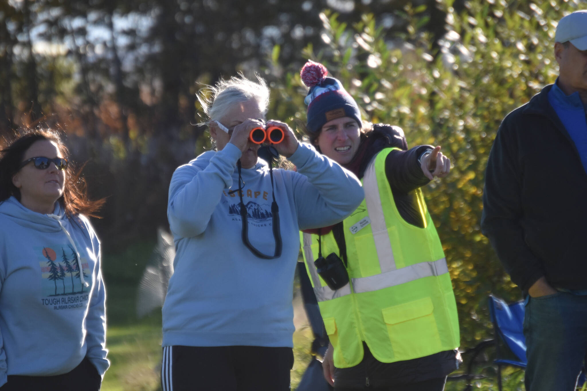 Nicole Schmitt (in yellow), director of the Alaska Wildlife Alliance, points out belugas for attendees of Belugas Count! on Saturday, Sept. 17, 2022, in Kenai, Alaska. (Jake Dye/Peninsula Clarion)