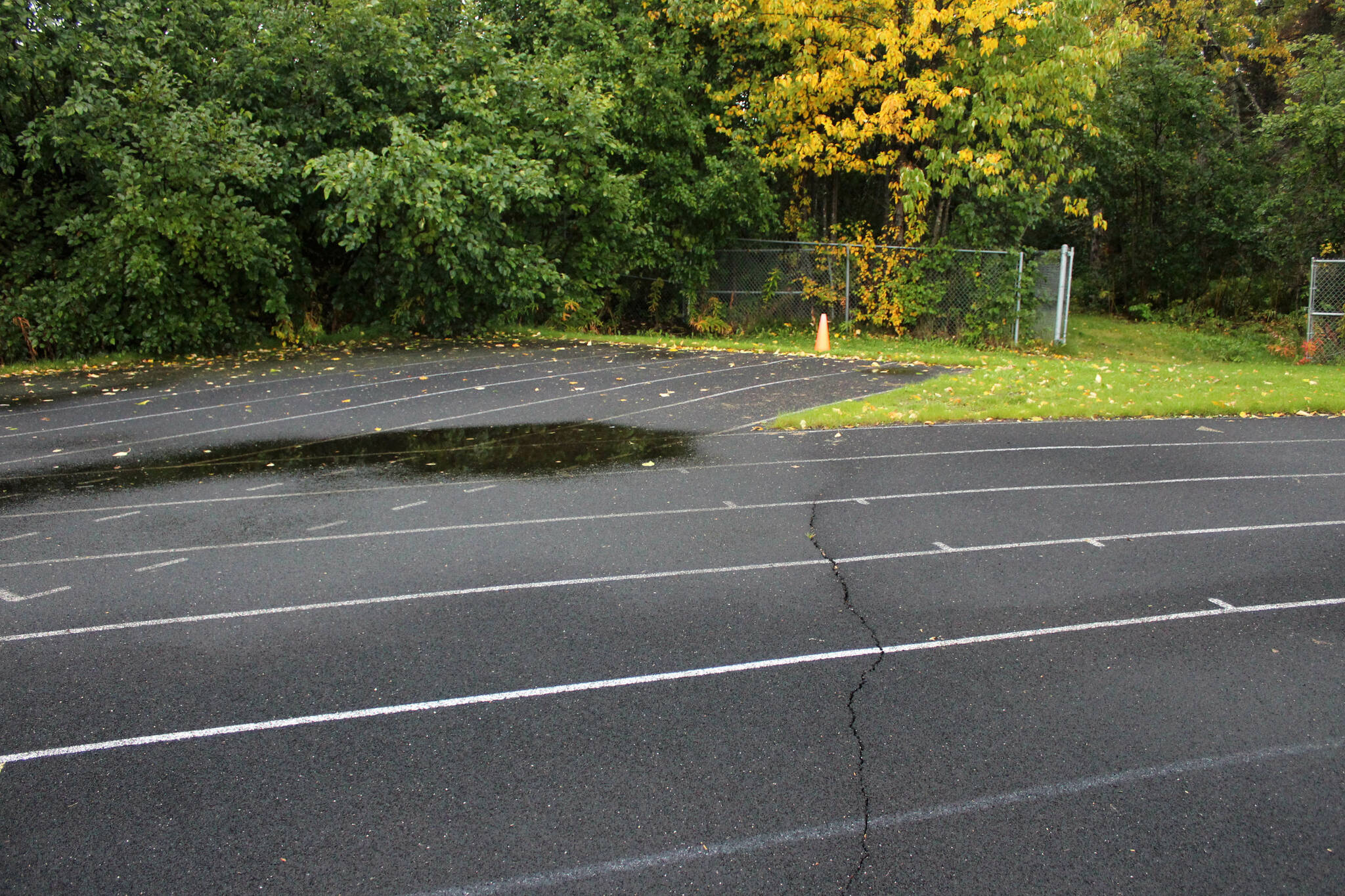A crack splits a warped track at Nikiski Middle/High School on Monday, Sept. 19, 2022, in Nikiski, Alaska. The track is one of several projects in a bond package Kenai Peninsula voters will consider during the Oct. 4 municipal election next month. (Ashlyn O’Hara/Peninsula Clarion)