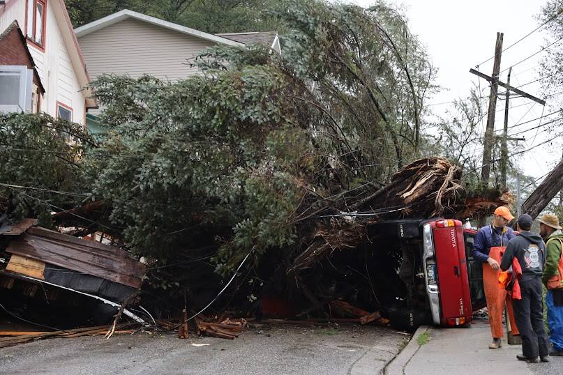 A resident’s truck laid on it’s side after being crushed by a large fallen tree the night before due to a landslide on Monday, Sept. 26, in Juneau, Alaska. (Clarise Larson / Juneau Empire)