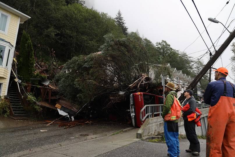 CCFR officials and residents gathered at the section of Gastineau Avenue that sustained damage from the landslide on on Monday, Sept. 26, in Juneau, Alaska. At the time of 8:30 a.m. on Tuesday officials said they were still trying to assess the damage and no cleanup efforts had started yet. (Clarise Larson / Juneau Empire)