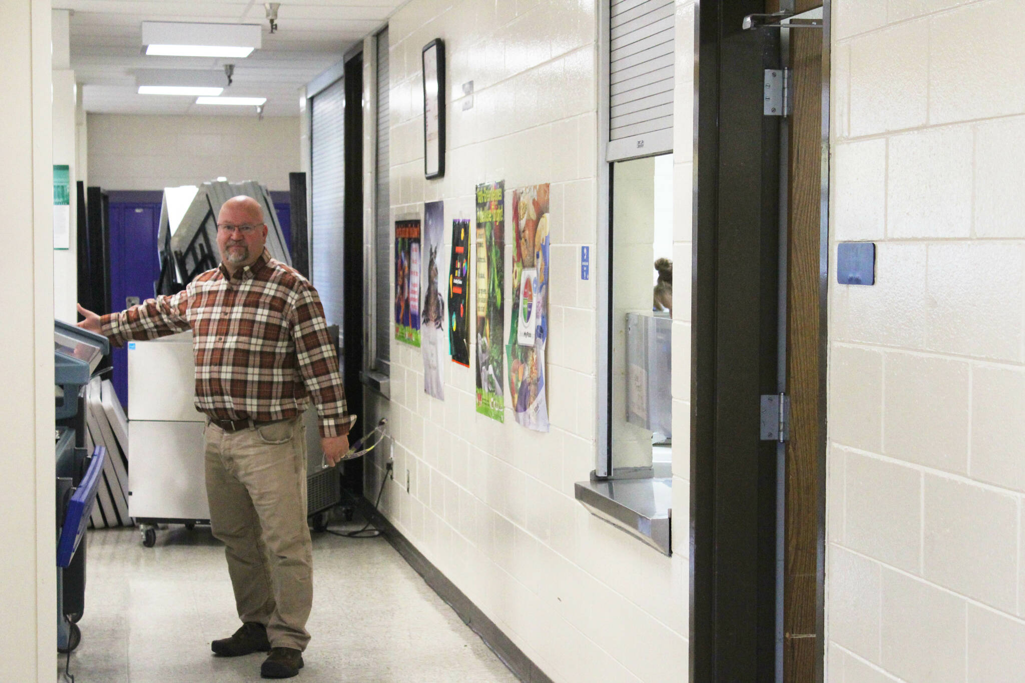 Kenai Middle School Principal Vaughn Dosko gestures toward a cart used to provide school lunch services on Wednesday, Sept. 21, 2022, in Kenai, Alaska. (Ashlyn O’Hara/Peninsula Clarion)