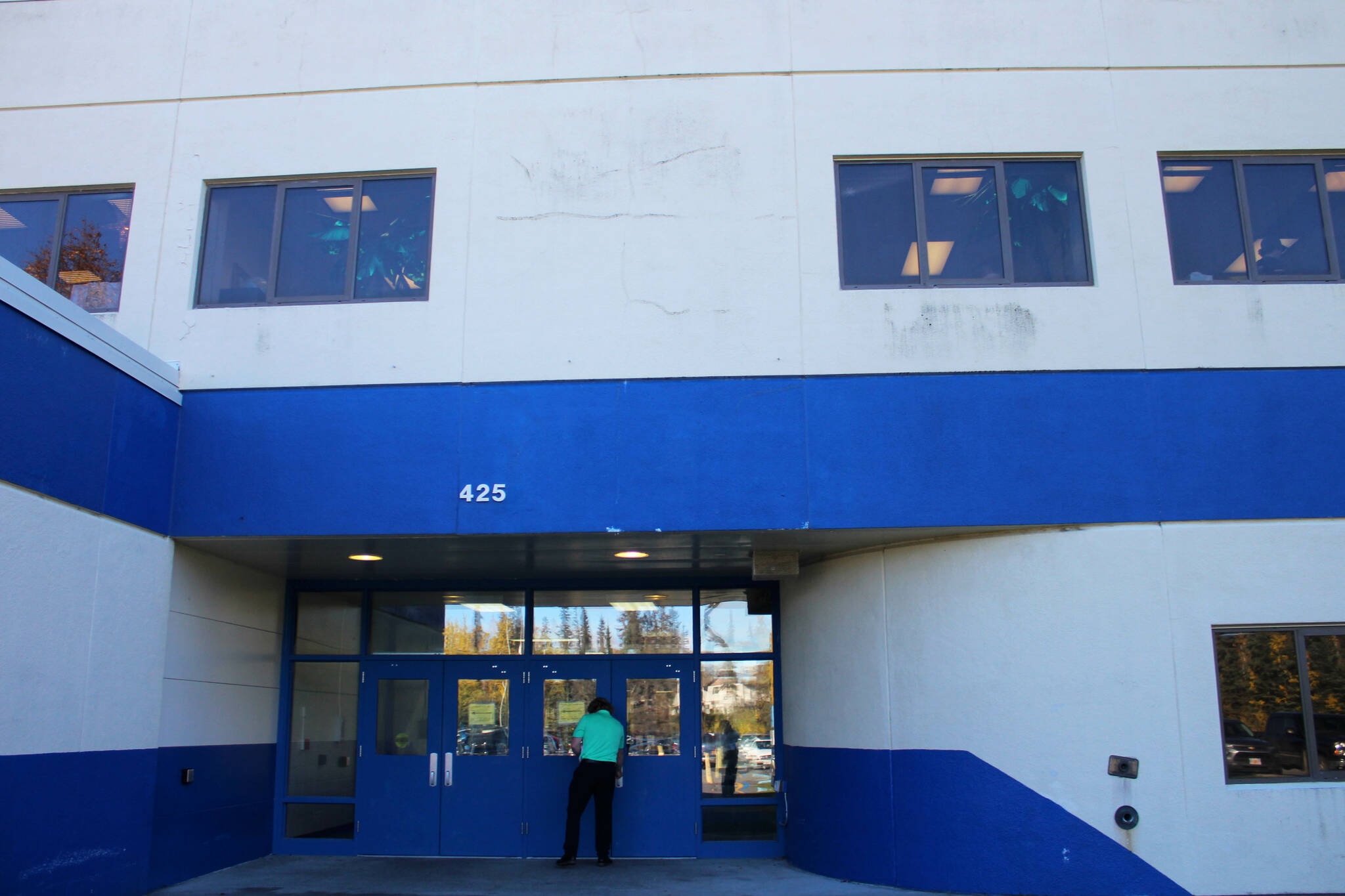 Principal Sarge Truesdell unlocks a door at Soldotna High School underneath cracked siding on Tuesday, Sept. 27, 2022, in Soldotna, Alaska. The siding is one of several projects in a bond package Kenai Peninsula voters will consider during the Oct. 4 municipal election. (Ashlyn OHara/Peninsula Clarion)