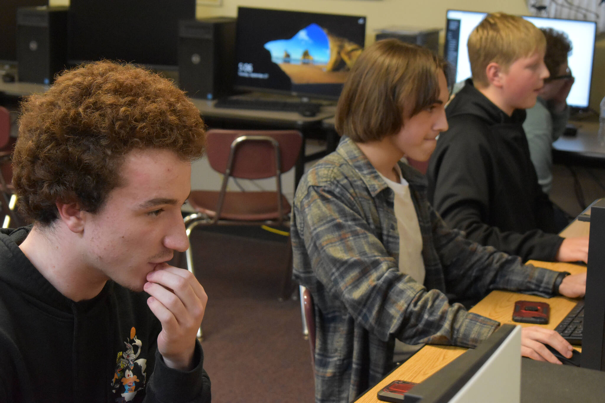 Kenai Central High School League of Legends players Silas Thibodeau, Cody Good and Roman Dunham tense up during the final push of the first game against Anchorage Christian Schools on Tuesday, Sept. 23, 2022, at Kenai Central High School in Kenai, Alaska. (Jake Dye/Peninsula Clarion)