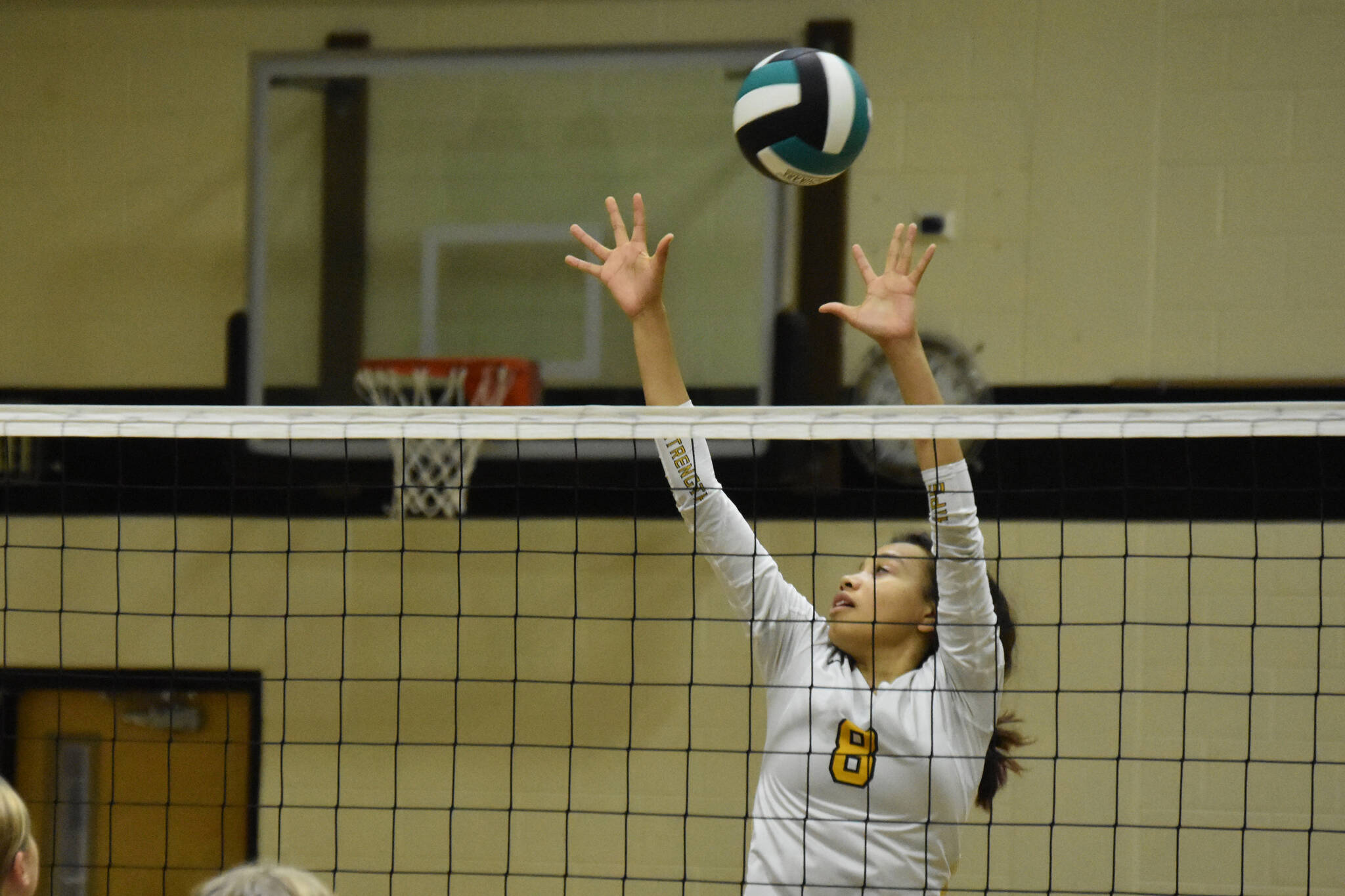 Nikiski's Alexa Iyatunguk leaps to block a ball on Thursday, Sept. 29, 2022 at Nikiski Middle/High School in Nikiski, Alaska. (Jake Dye/Peninsula Clarion)