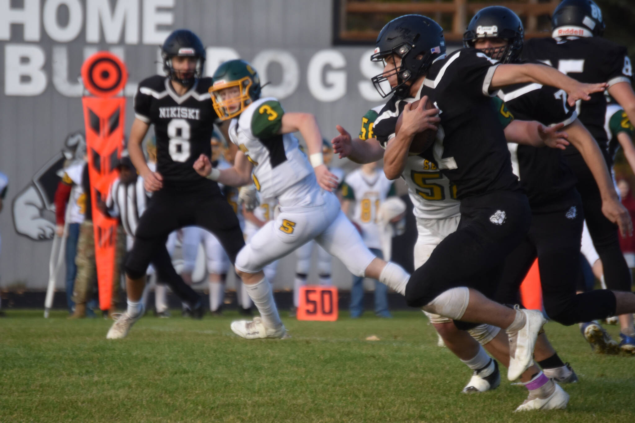 Nikiski’s Dwyght Mullins runs with the ball, pursued by Seward’s Brett Gilmore during the Denali Conference title match on Friday, Sept. 30, 2022 at Nikiski High School in Nikiski, Alaska. (Jake Dye/Peninsula Clarion)