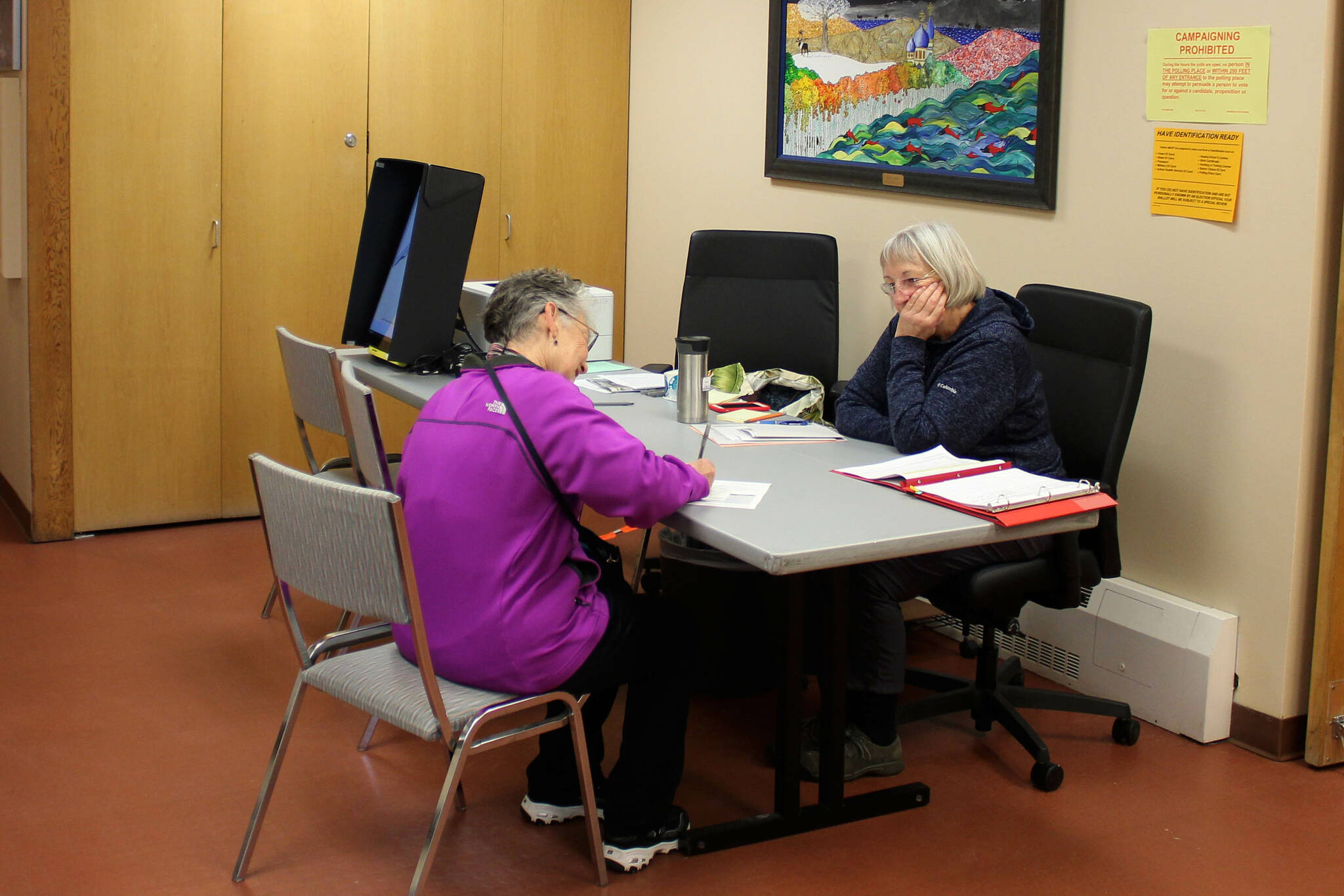 Carol Freas (right) helps a voter fill out absentee election materials in Kenai City Hall ahead of the Oct. 4 municipal election on Thursday, Sept. 29, 2022 in Kenai, Alaska. (Ashlyn O’Hara/Peninsula Clarion)