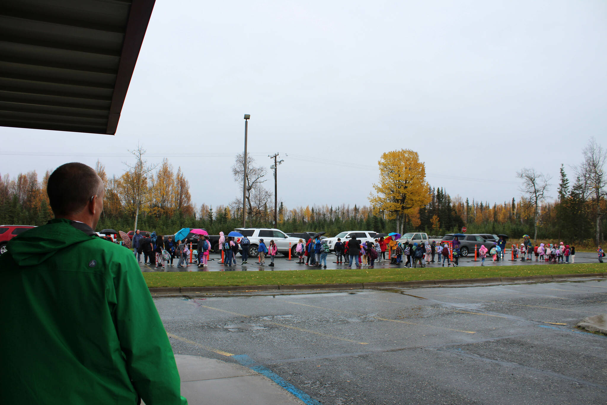Mountain View Elementary School Principal Karl Kircher (green) helps direct student pick up traffic at the end of the school day on Thursday, Sept. 29, 2022, in Kenai, Alaska. (Ashlyn OHara/Peninsula Clarion)