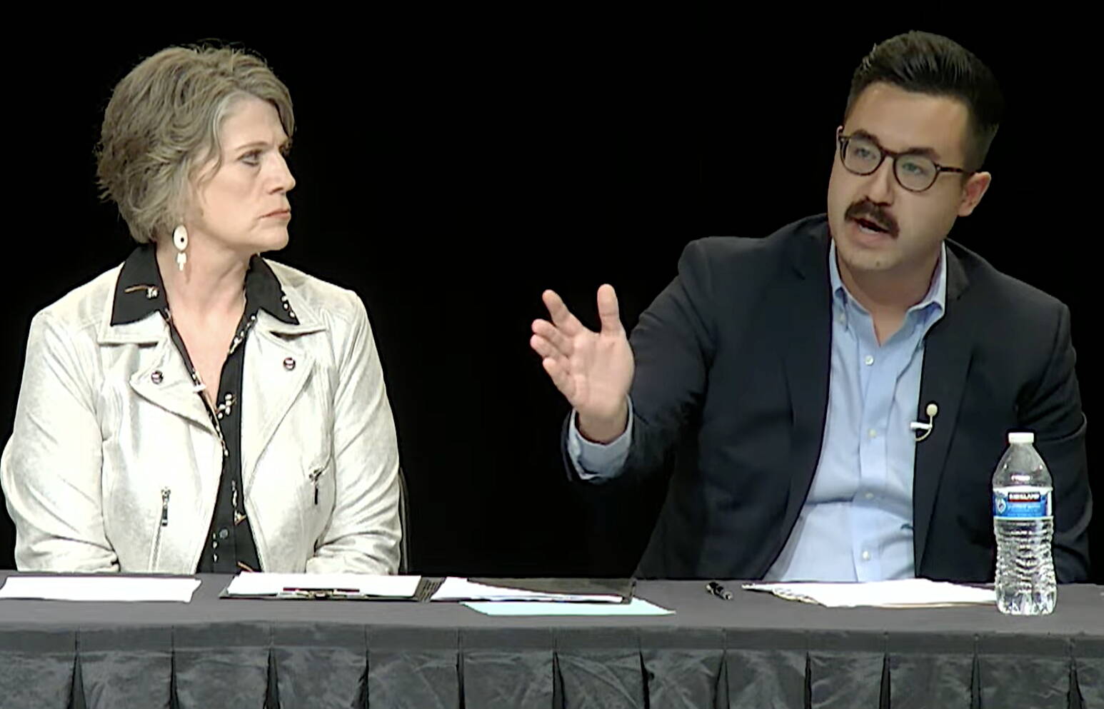 Joelle Hall, left, president of the Alaska AFL-CIO, listens to Matt Shuckerow, a spokesperson for a group opposed to a state constitutional convention, argue his case during Thursday night’s debate. (Screenshot from Alaska Public Media’s YouTube channel)