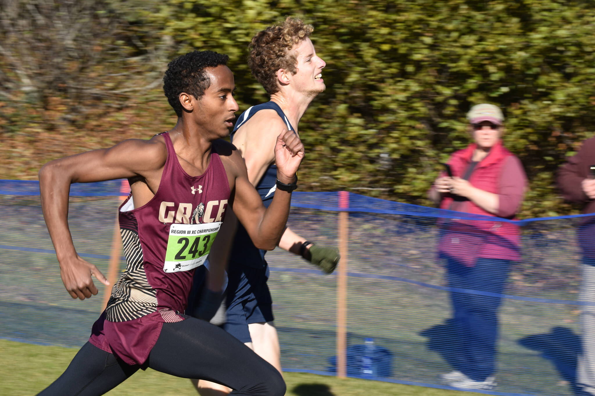 Grace Christian’s David Sliwinski and Homer’s Seamus McDonough both make their last push to the finish chute during the Region 3/Division II race on Saturday, Oct. 1, 2022, at Tsalteshi Trails just outside of Soldotna Alaska. (Jake Dye/Peninsula Clarion)