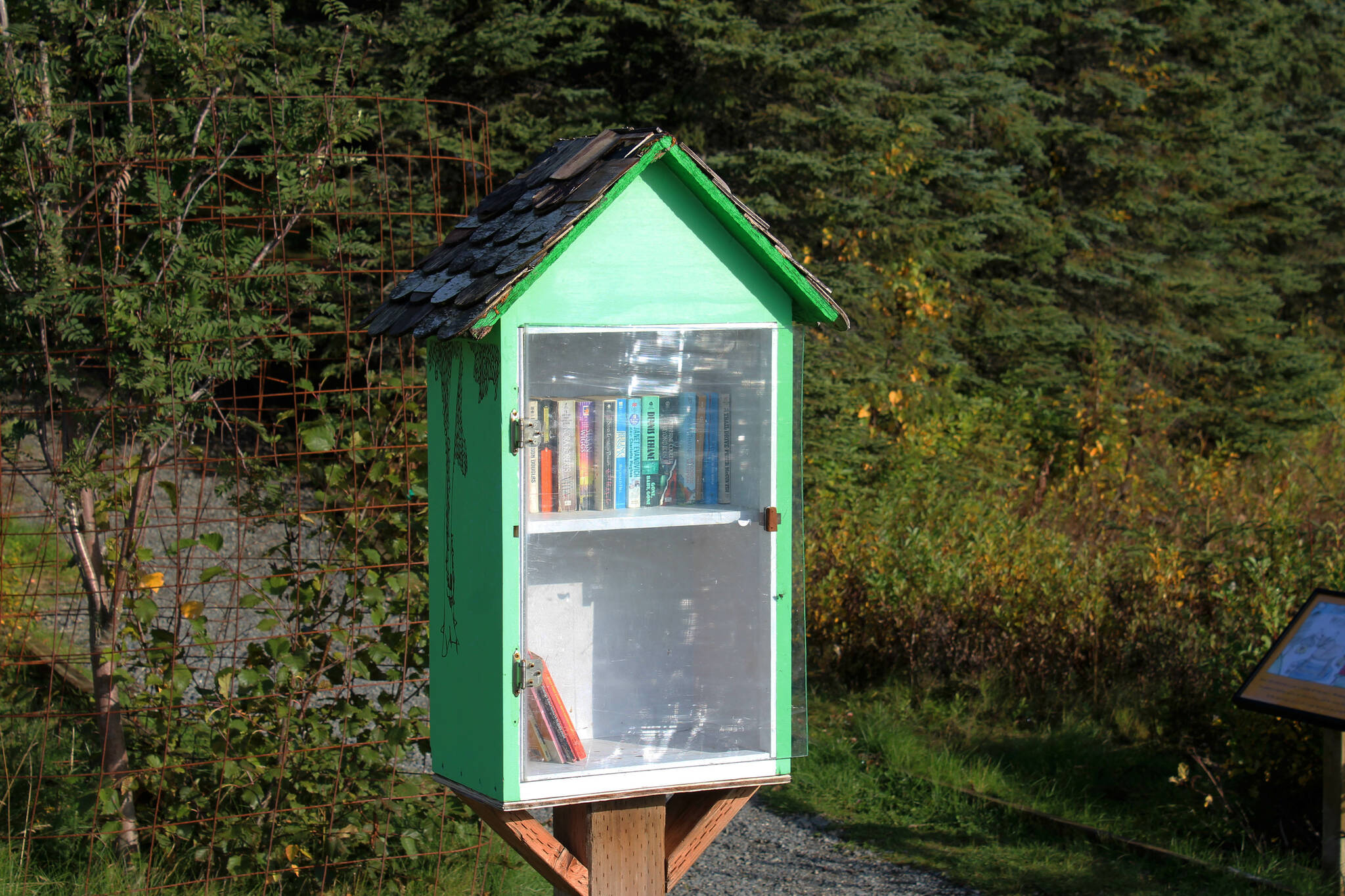 A mini-library contains books at Daubnespeck Park on Monday, Oct. 3, 2022, in Kenai, Alaska. (Ashlyn O’Hara/Peninsula Clarion)