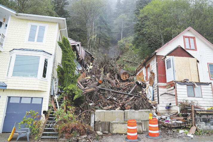Clarise Larson/ Juneau Empire 
Two cones sit and concrete barriers separate the fallen trees and debris left over after a landslide occurred early last week, on Thursday. Officials determined in the aftermath of the event that the landslide occurred predominantly due to a large tree that fell and in the process pulled down mud and other debris with it as it slid down the hillside.