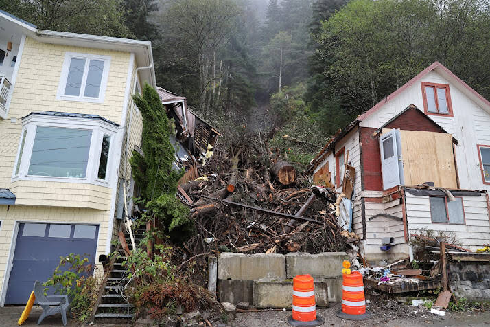 Two cones and concrete barriers sit near the fallen trees and debris left over after a landslide occurred early last week. Officials determined in the aftermath of the event that the landslide occurred predominantly due to a large tree that fell and in the process pulled down mud and other debris with it as it slid down the hillside. (Clarise Larson/ Juneau Empire)