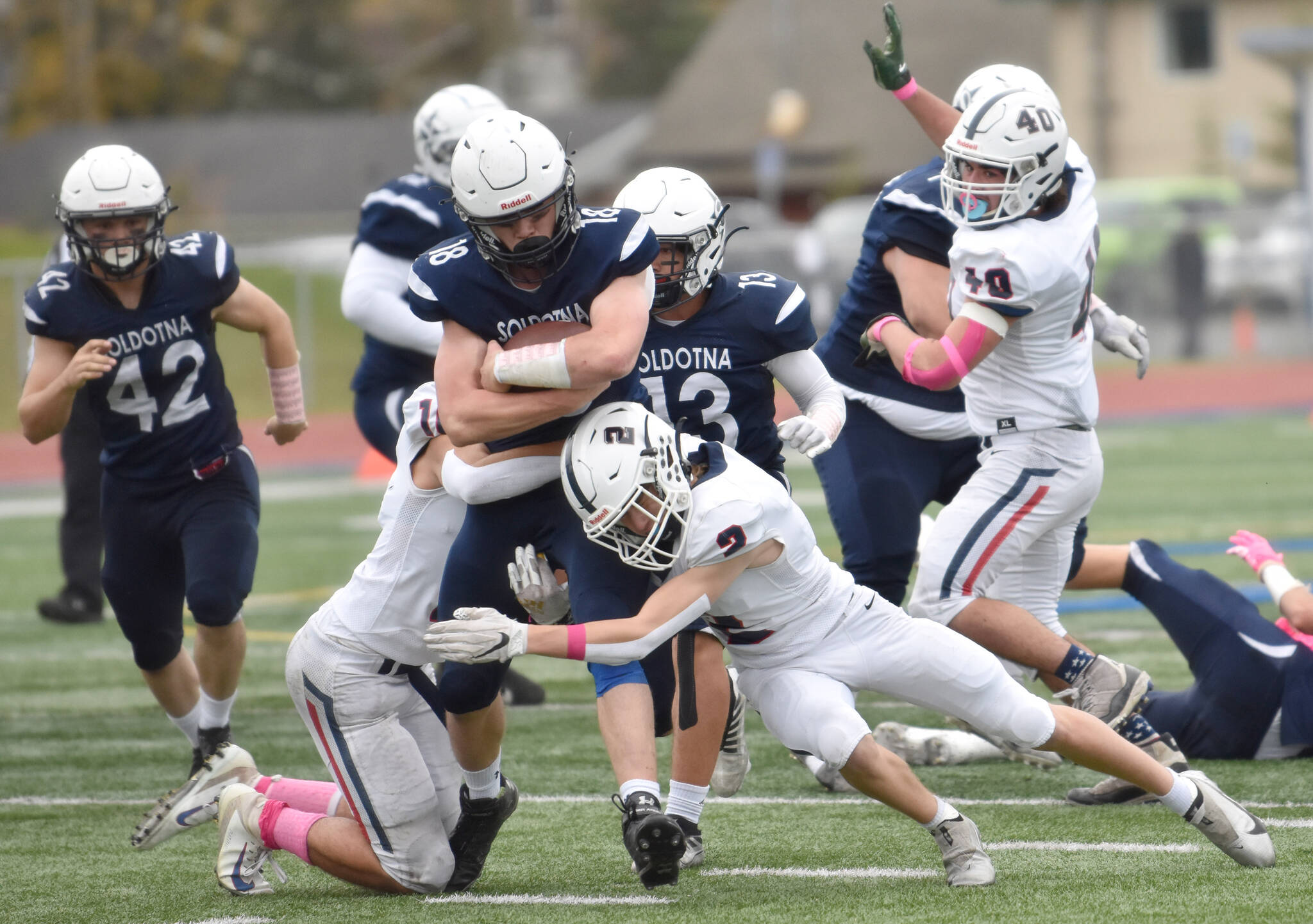 Soldotna’s Collin Peck is tackled by North Pole’s Logan Fischer and Trevor Walters on Friday, Oct. 7, 2022, at Justin Maile Field at Soldotna High School in Soldotna, Alaska. (Photo by Jeff Helminiak/Peninsula Clarion)