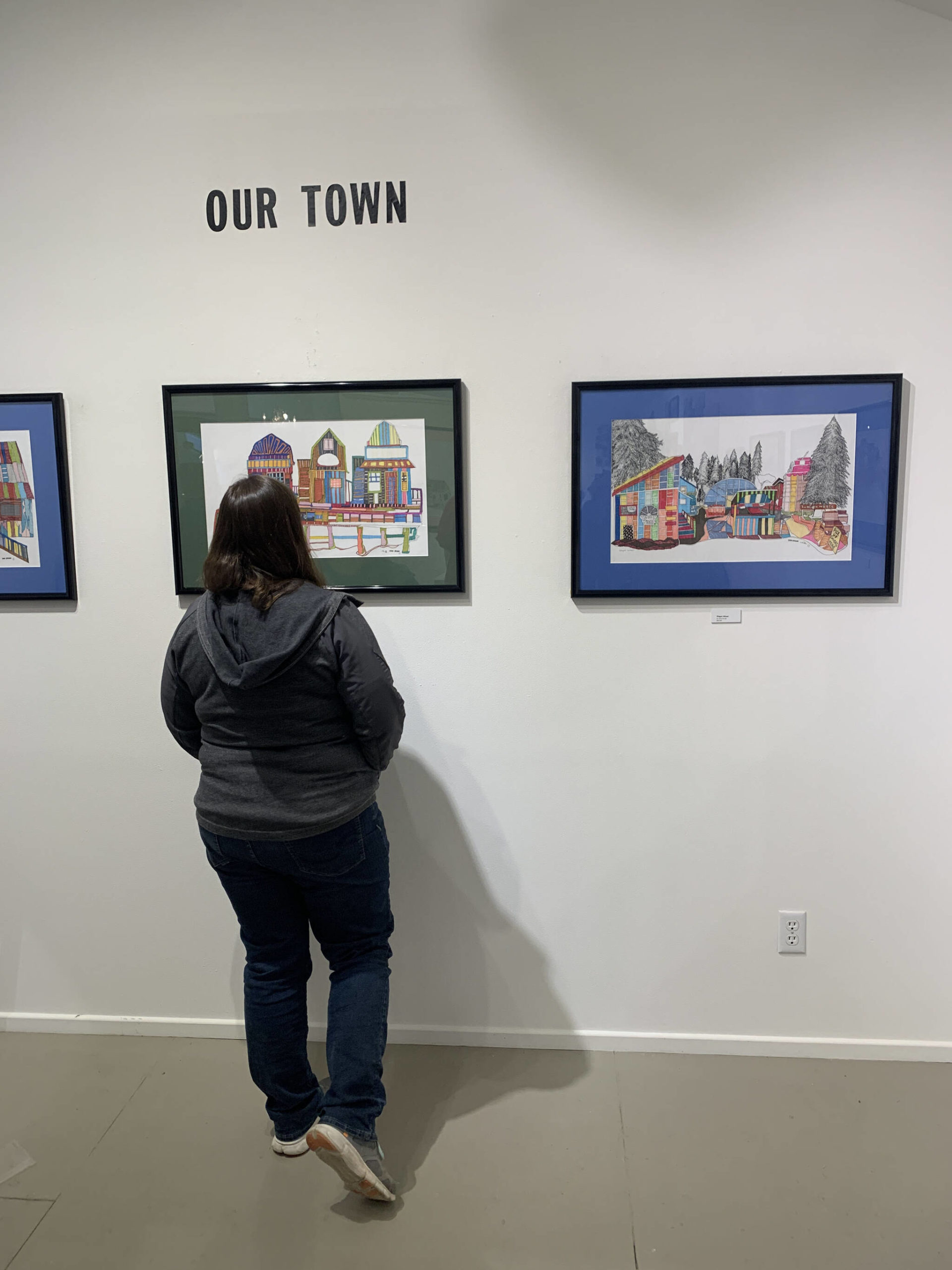 A community member views work in the Our Town exhibit at Fireweed Gallery during First Friday, Oct. 7, 2022, in Homer, Alaska. (Photo by Christina Whiting/Homer News)