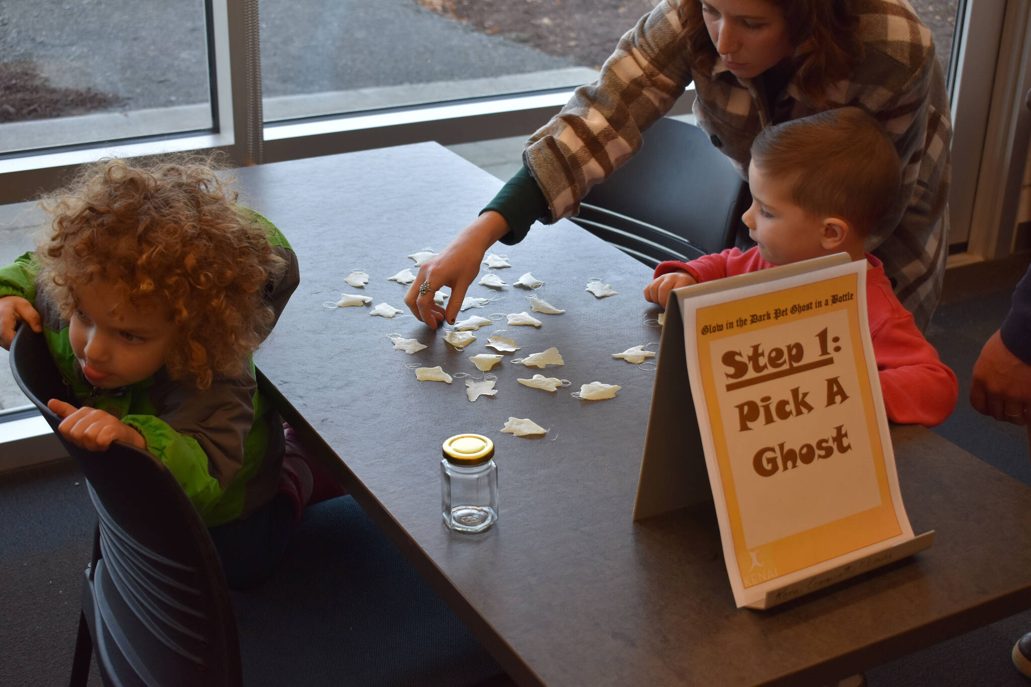 Kids pick out their new pet ghosts at the Kenai Community Library in Kenai, Alaska on Friday, Oct. 14, 2022. (Jake Dye/Peninsula Clarion)