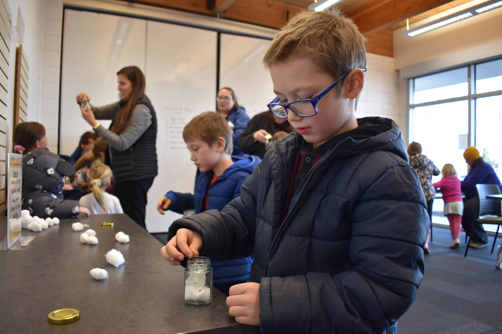 Kids put their new pet ghosts into bottles at the Kenai Community Library in Kenai, Alaska on Friday, Oct. 14, 2022. (Jake Dye/Peninsula Clarion)