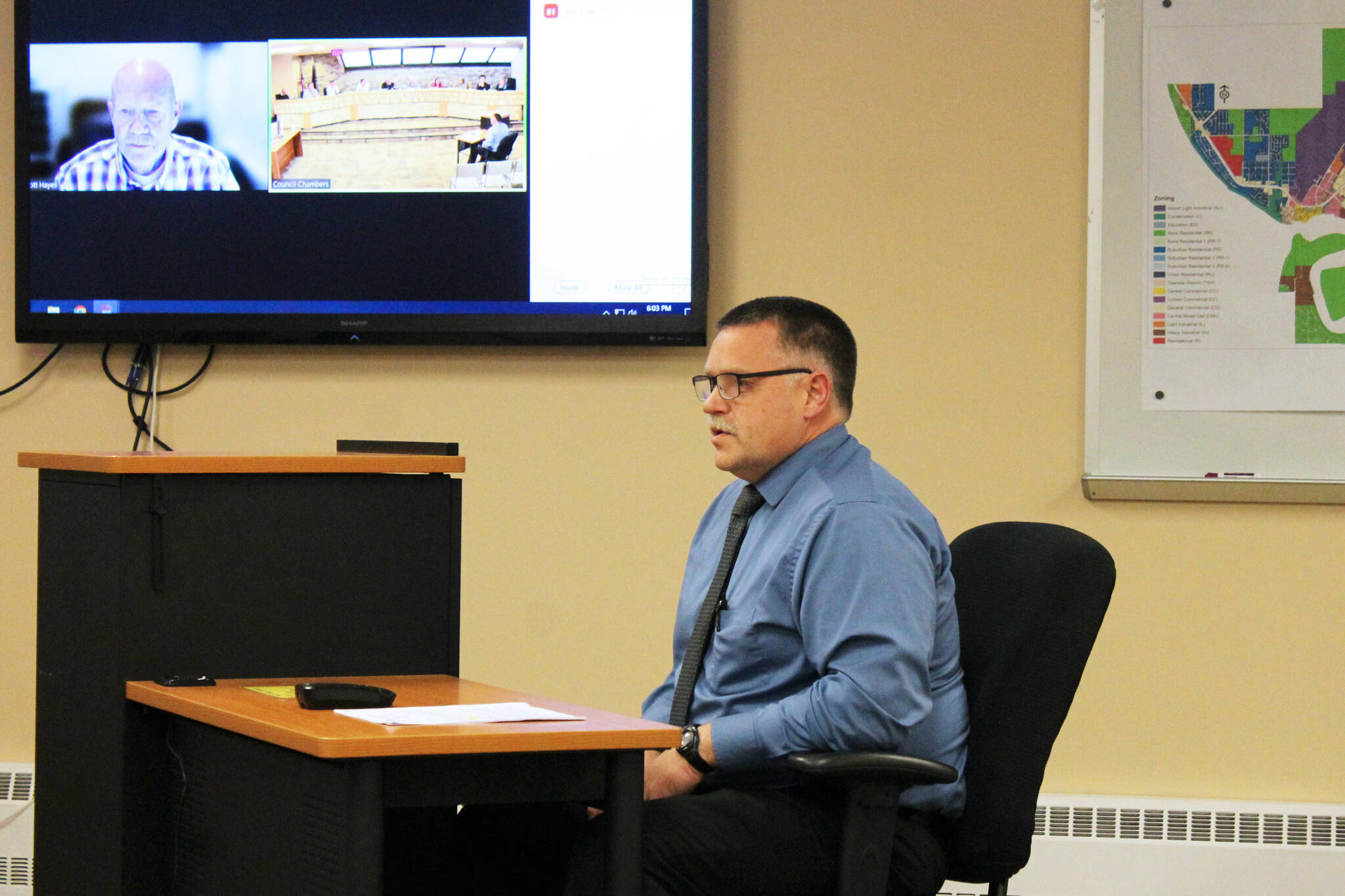 Oregon Accreditation Alliance Executive Director Scott Hayes, monitor, and Kenai Police Chief David Ross, right, field questions from the Kenai City Council regarding the department’s accreditation during a council meeting on Wednesday, Oct. 5, 2022, in Kenai, Alaska. (Ashlyn O’Hara/Peninsula Clarion)