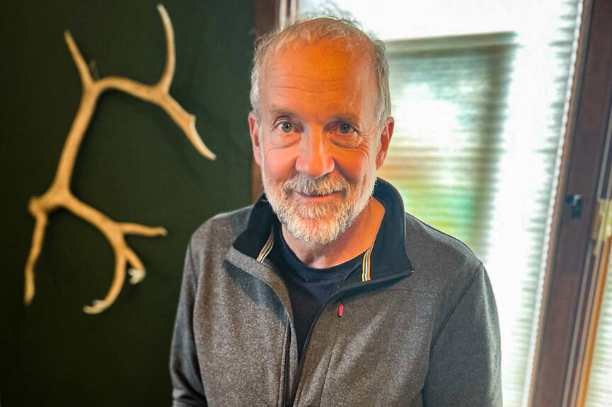 Tom Kizzia poses with a stack of his book, “Cold Mountain Path,” on Sept. 1, 2021. (Photo provided)