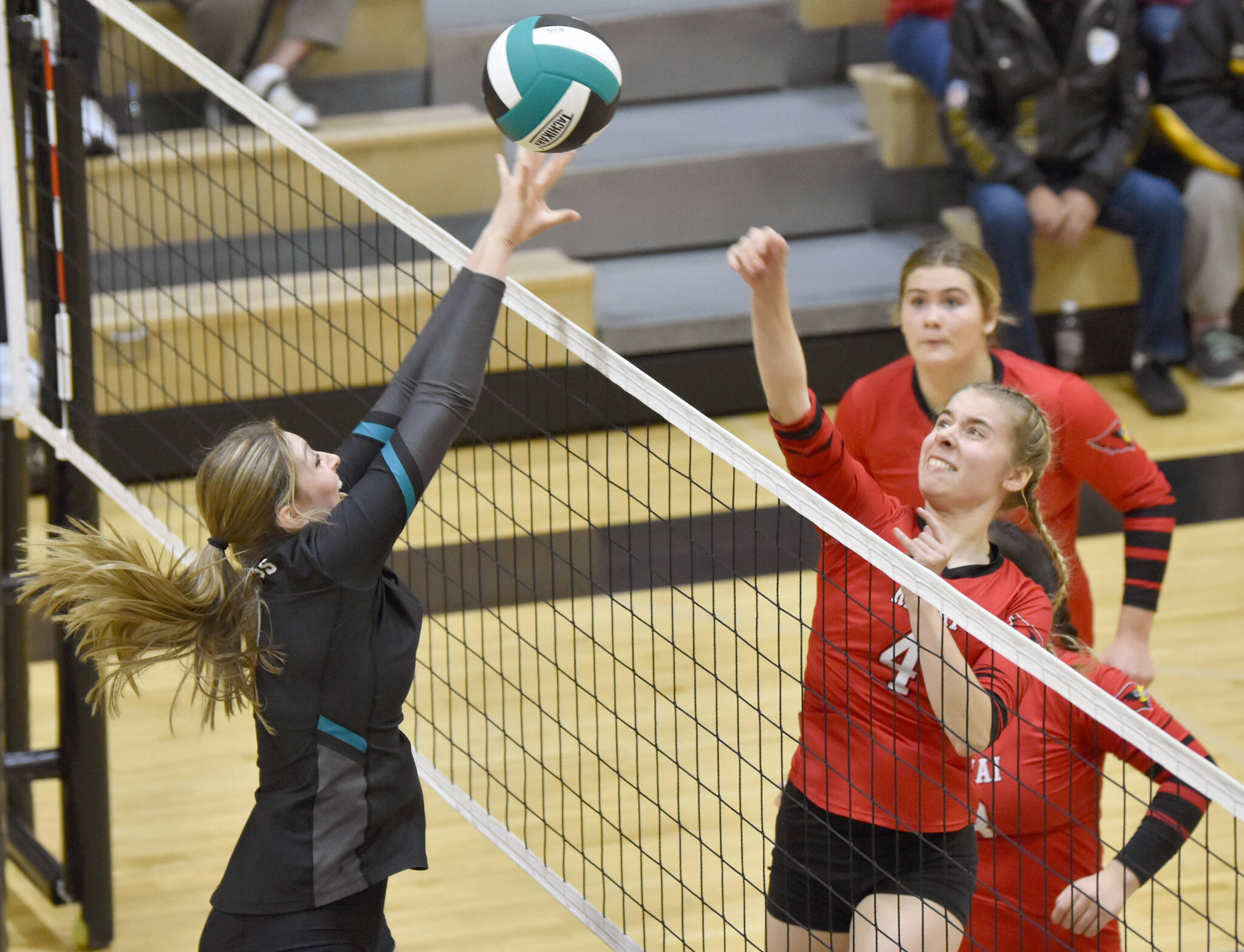 Kenai Central’s Avia Miller attacks on Nikiski’s Ashlynne Playle on Tuesday, Oct. 18, 2022, at Nikiski High School in Nikiski, Alaska. (Photo by Jeff Helminiak/Peninsula Clarion)