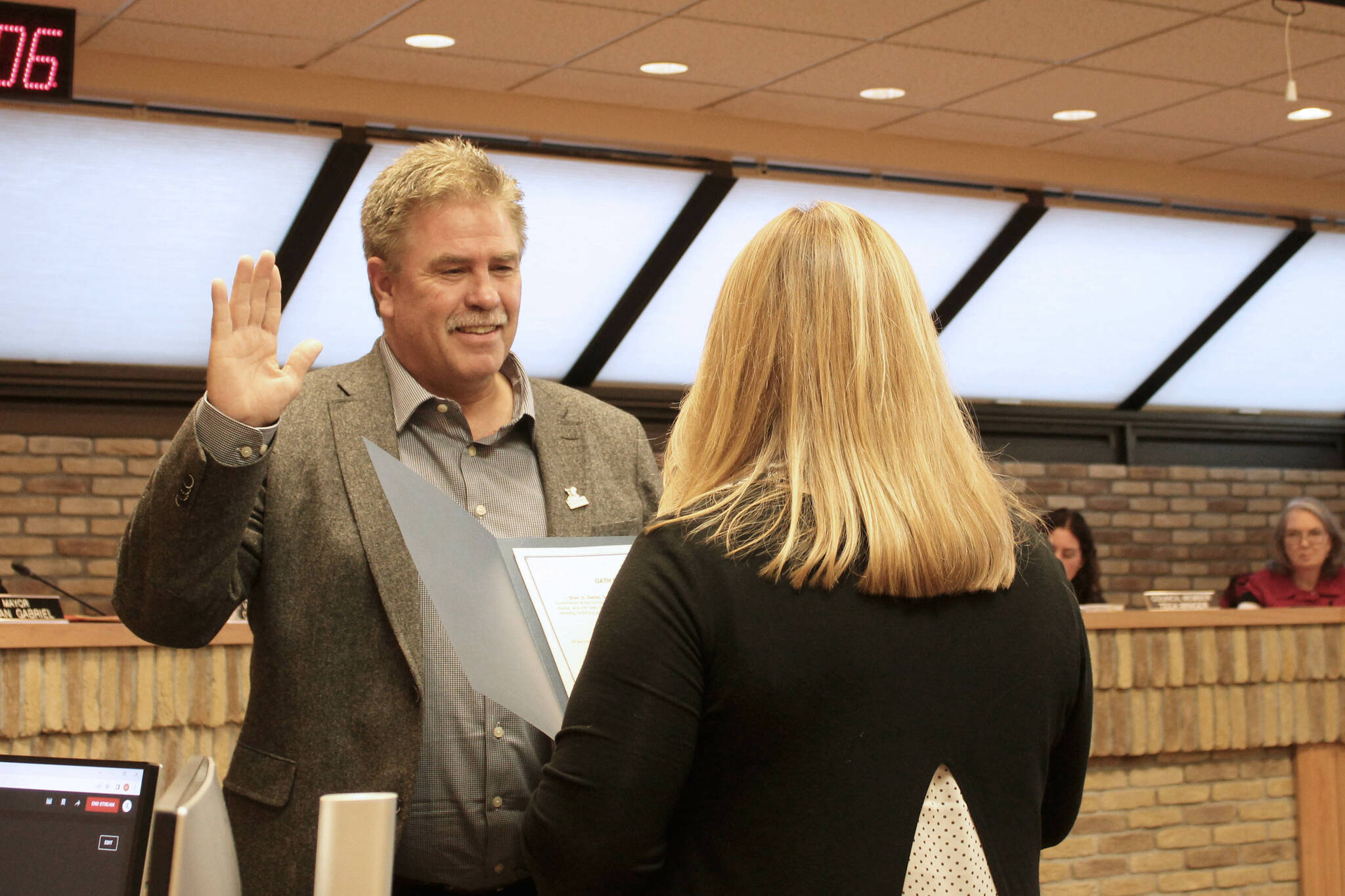 Kenai City Clerk Shellie Saner, right, swears in Kenai Mayor Brian Gabriel during a Kenai City Council meeting on Wednesday, Oct. 19, 2022, in Kenai, Alaska. (Ashlyn O’Hara/Peninsula Clarion)