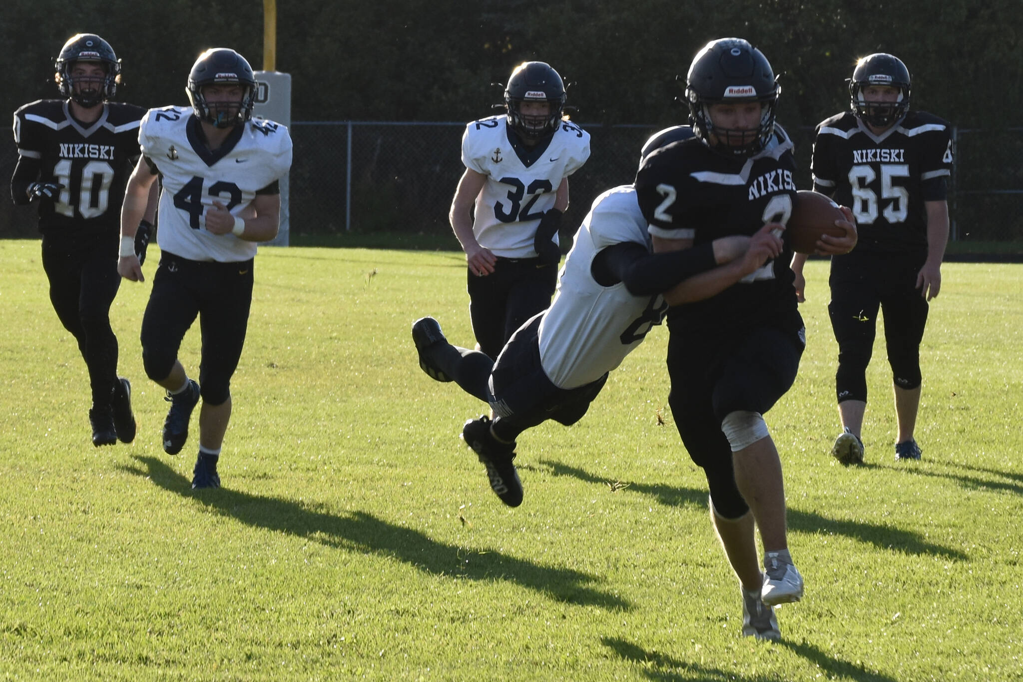 Nikiski’s Dwyght Mullins is tackled by Homer’s Austin Hanson on Friday, Sept. 23, 2022, at Nikiski High School in Nikiski, Alaska. (Jake Dye/Peninsula Clarion)