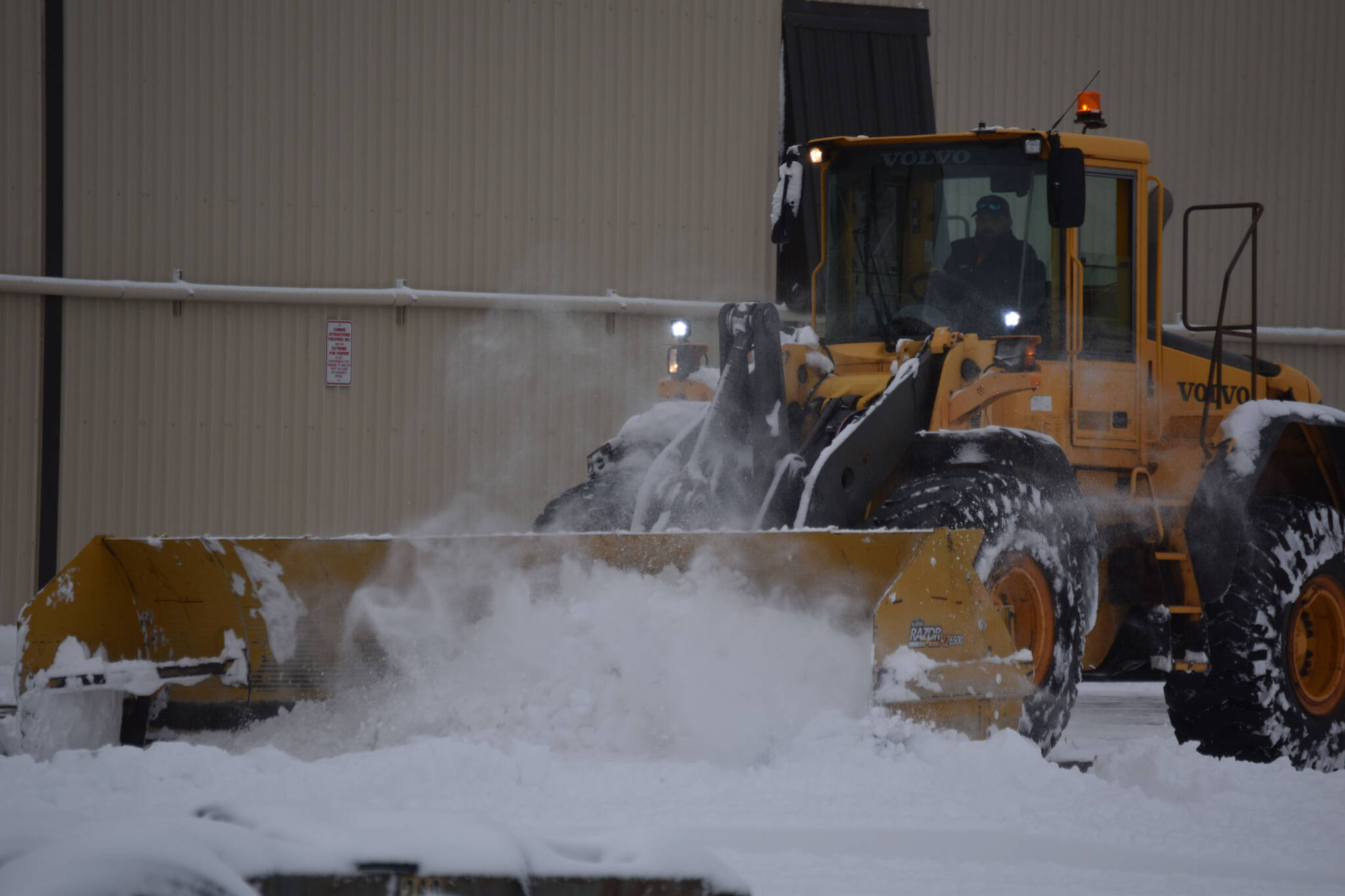 Snow is cleared from the parking lot at Kenai Cinema in Kenai, Alaska on Wednesday, Oct. 26, 2022. (Jake Dye/Peninsula Clarion)