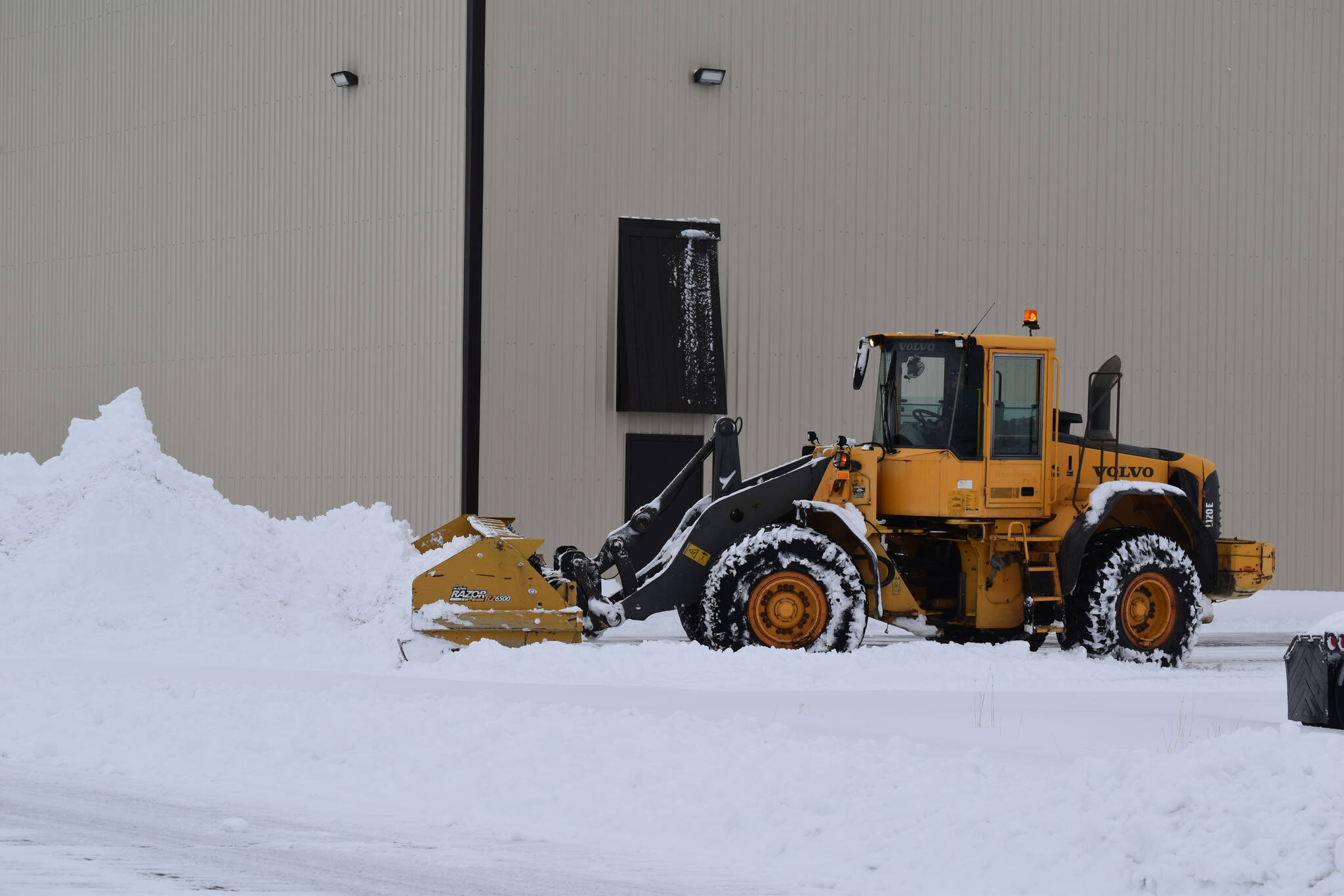 Snow is cleared from the parking lot at Kenai Cinema in Kenai, Alaska on Wednesday, Oct. 26, 2022. (Jake Dye/Peninsula Clarion)