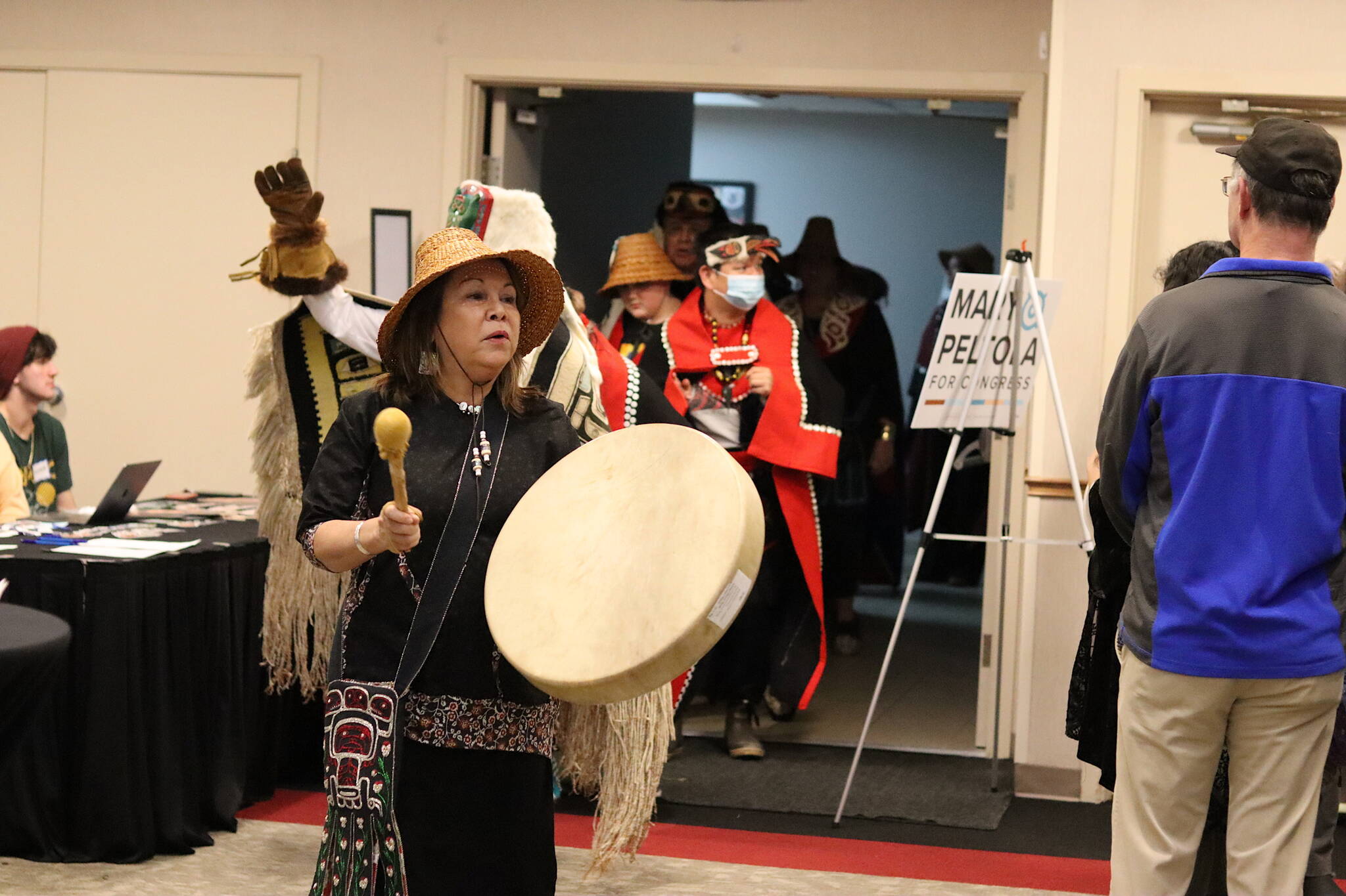 Nancy Barnes, a member of the Yees Ku Oo Dancers, leads a procession into the convention room at Elizabeth Peratrovich Hall on Monday to begin a reelection event for U.S. Rep. Mary Peltola. Barnes said she has known Peltola since the Congresswoman was an intern for KTOO more than 20 years ago and “I knew she was going to do big things.” (Mark Sabbatini / Juneau Empire)
