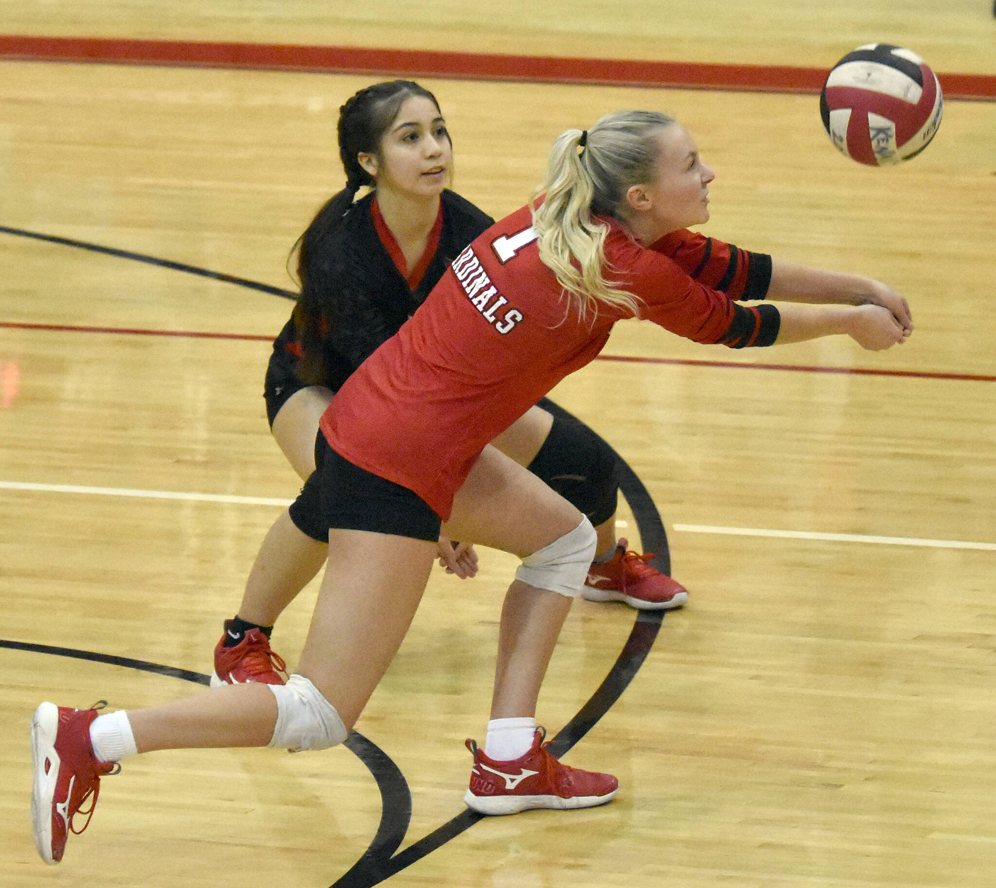 Kenai Central’s Kimberly Chanley digs up a ball in front of Jaycie Castillo on Friday, Oct. 28, 2022, at Kenai Central High School in Kenai, Alaska. (Photo by Jeff Helminiak/Peninsula Clarion)