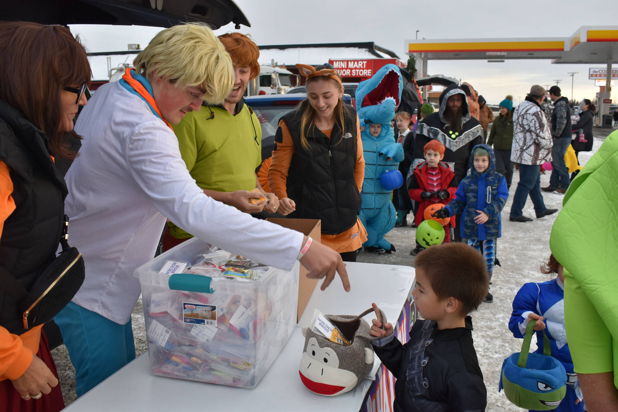 The Walden Bros. team hands candy to kids at the Orca Theater’s Trunk or Treat in Soldotna, Alaska, on Monday, Oct. 31, 2022. (Jake Dye/Peninsula Clarion)