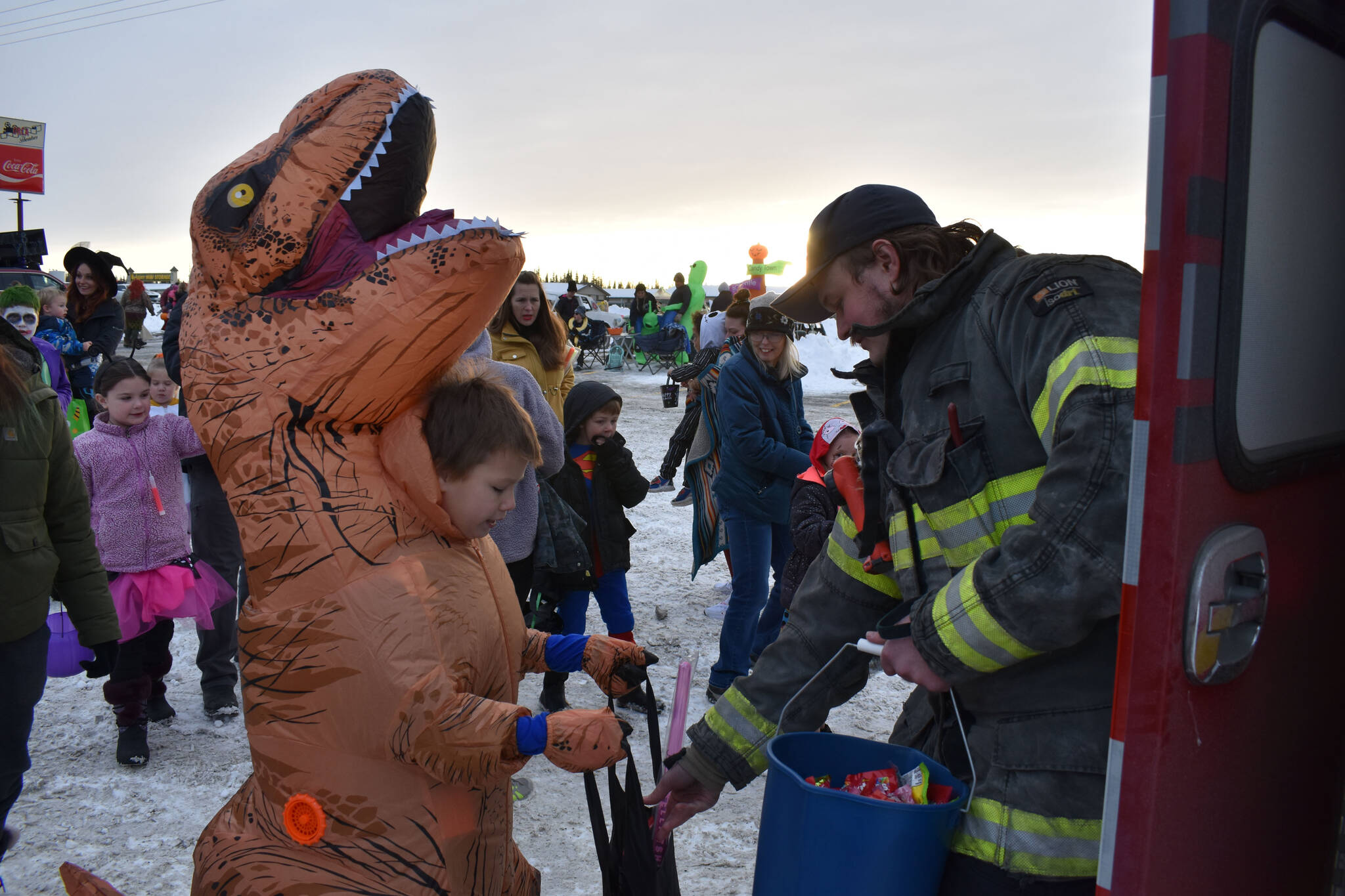 Central Emergency Services staff hand candy to kids at the Orca Theater’s Trunk or Treat in Soldotna, Alaska, on Monday, Oct. 31, 2022. (Jake Dye/Peninsula Clarion)
