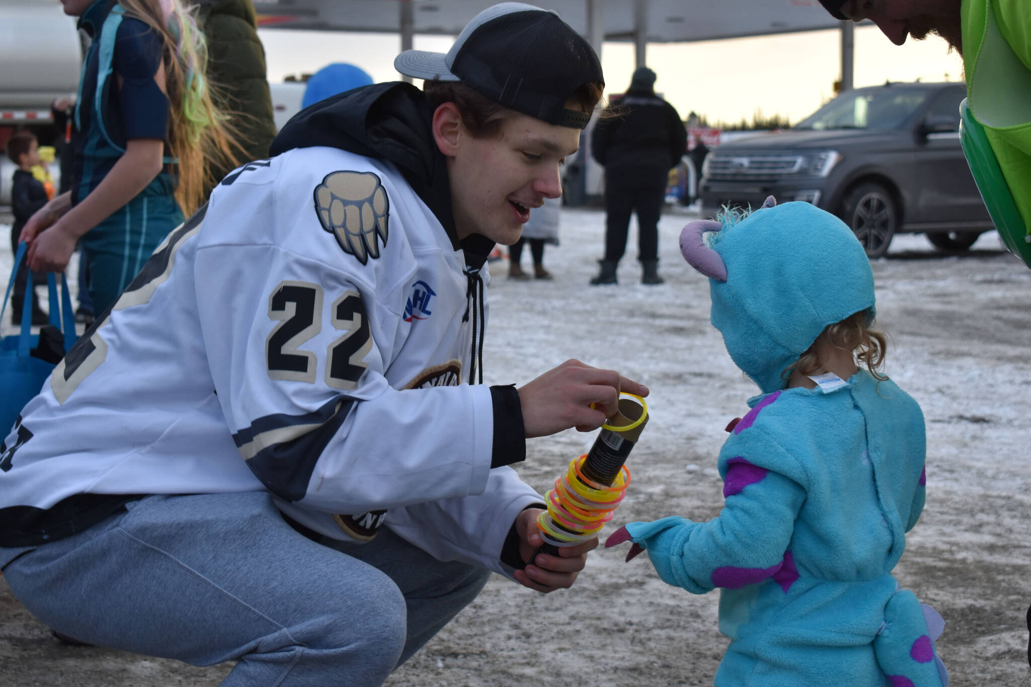 Ashton Christman hands out glow bracelets at the Orca Theater’s Trunk or Treat in Soldotna, Alaska, on Monday, Oct. 31, 2022. (Jake Dye/Peninsula Clarion)