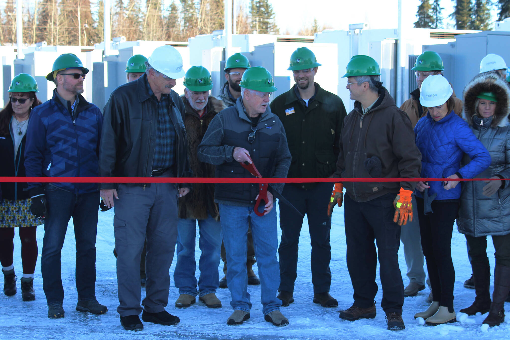 Homer Electric Association Board of Directors Dan Furlong, center, cuts the ribbon at a ceremony celebrating HEA’s Tesla battery energy storage system on Tuesday, Nov. 1, 2022, near Soldotna, Alaska. (Ashlyn O’Hara/Peninsula Clarion)