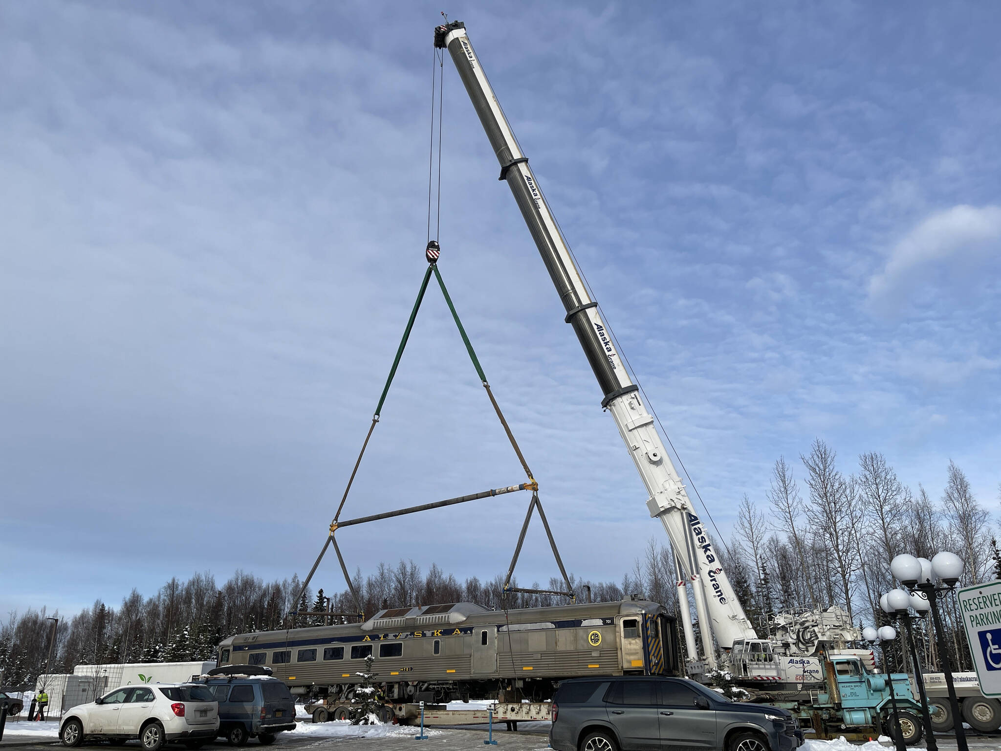 A new train car is hooked to a massive crane in preparation for placement on Whistle Hill in Soldotna, Alaska, on Saturday, Oct. 29, 2022. (Jake Dye/Peninsula Clarion)
