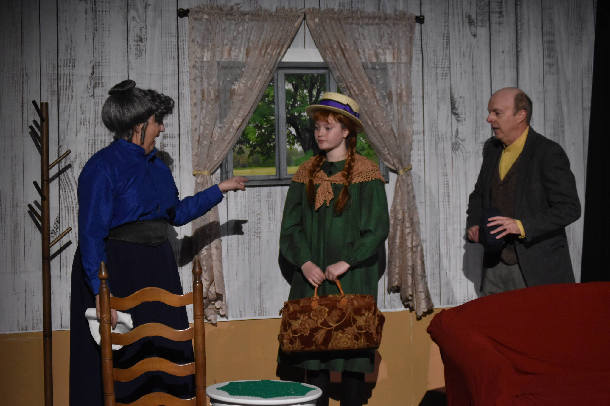 From left, Donna Shirnberg portrays Marilla Cuthbert, Truly Hondel portrays Anne Shirley, and Todd Sherwood portrays Matthew Cuthbert in a rehearsal of “Anne of Green Gables” at the Kenai Performers Black Box Theatre in Soldotna, Alaska, on Tuesday, Nov. 1, 2022. (Jake Dye/Peninsula Clarion)